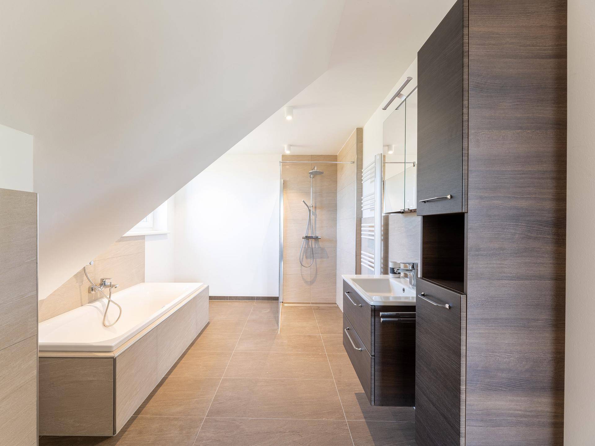 Modernes Badezimmer mit Fliesenboden, Badewanne unter Dachschräge und begehbarer Dusche.