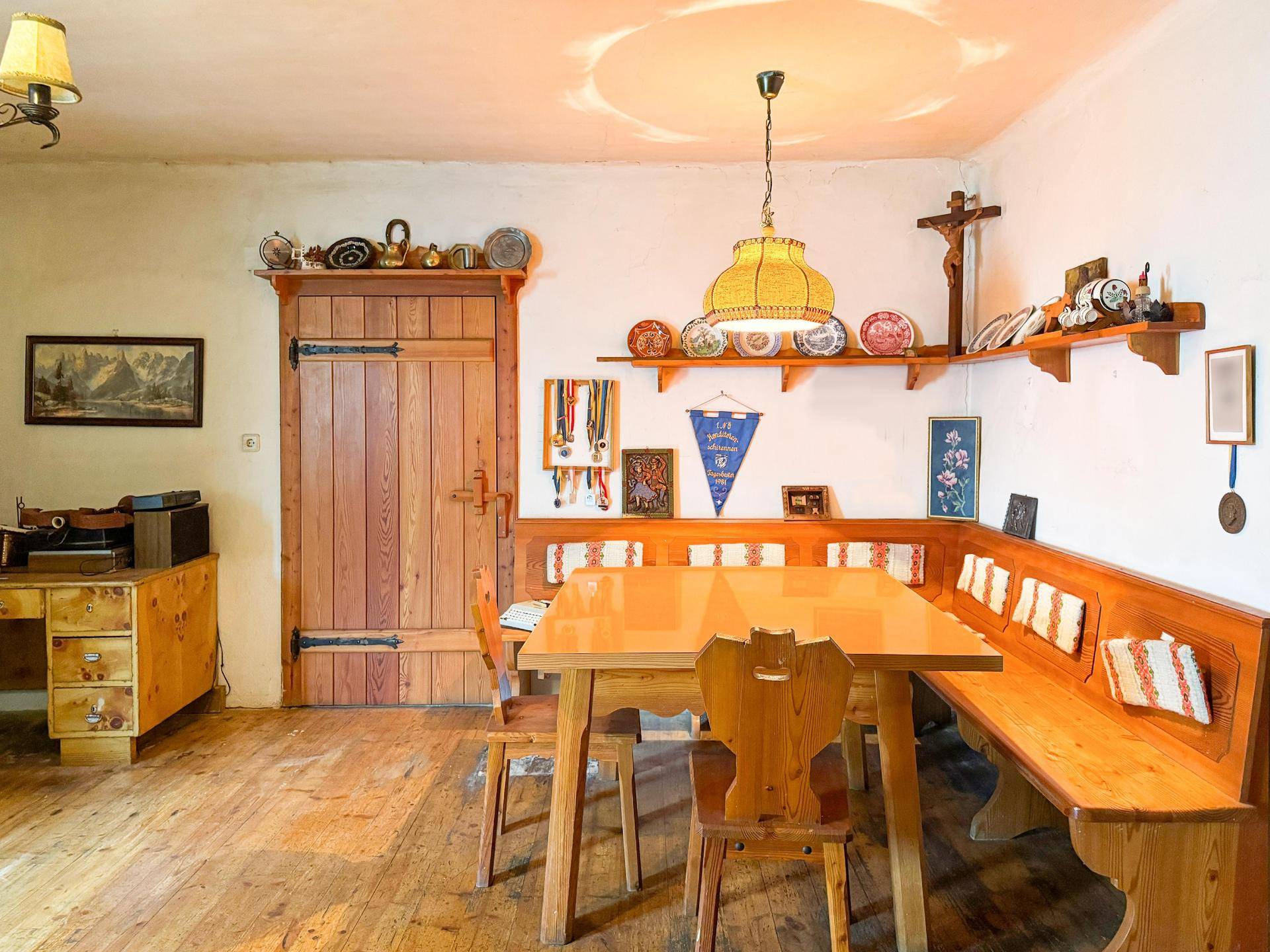 Rustikaler Essbereich mit großer Eckbank, Holztisch und traditioneller Dekoration.