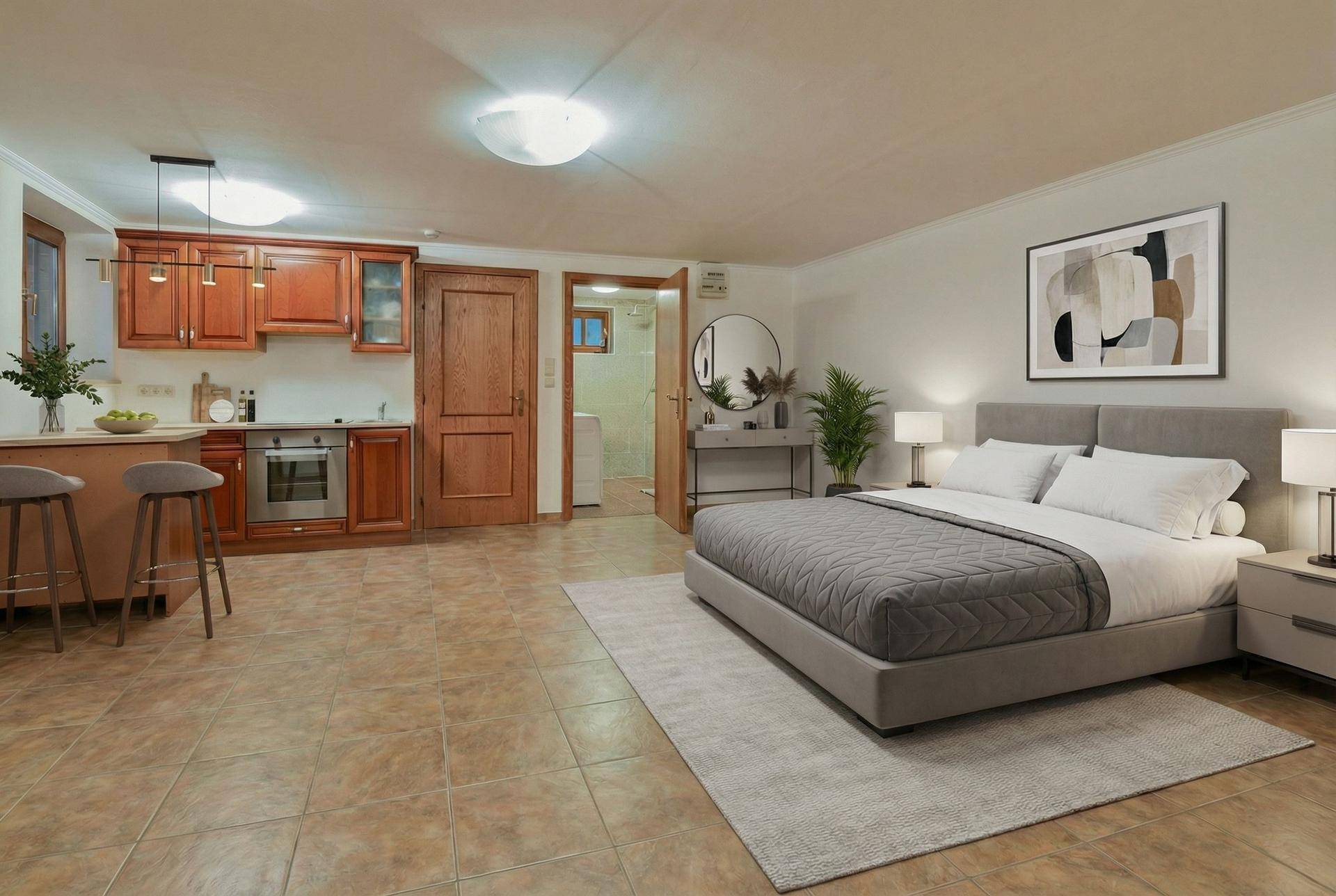 Modernisierter Kellerraum mit Bett, kleiner Küchenzeile und heller Einrichtung, als Wohnraum nutzbar.