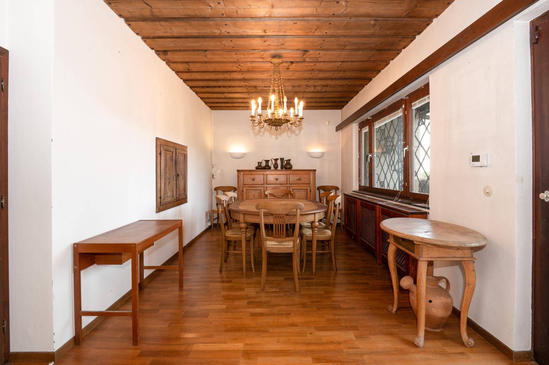 Klassischer Essbereich mit Holztisch, passenden Stühlen und einer Holzbalkendecke.