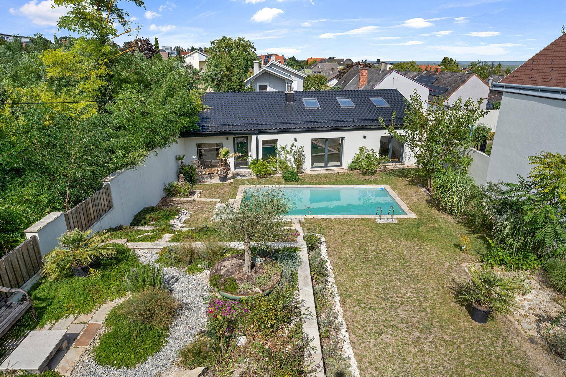 Luftaufnahme des Hauses mit großem Garten, Pool und gepflegten Grünflächen.