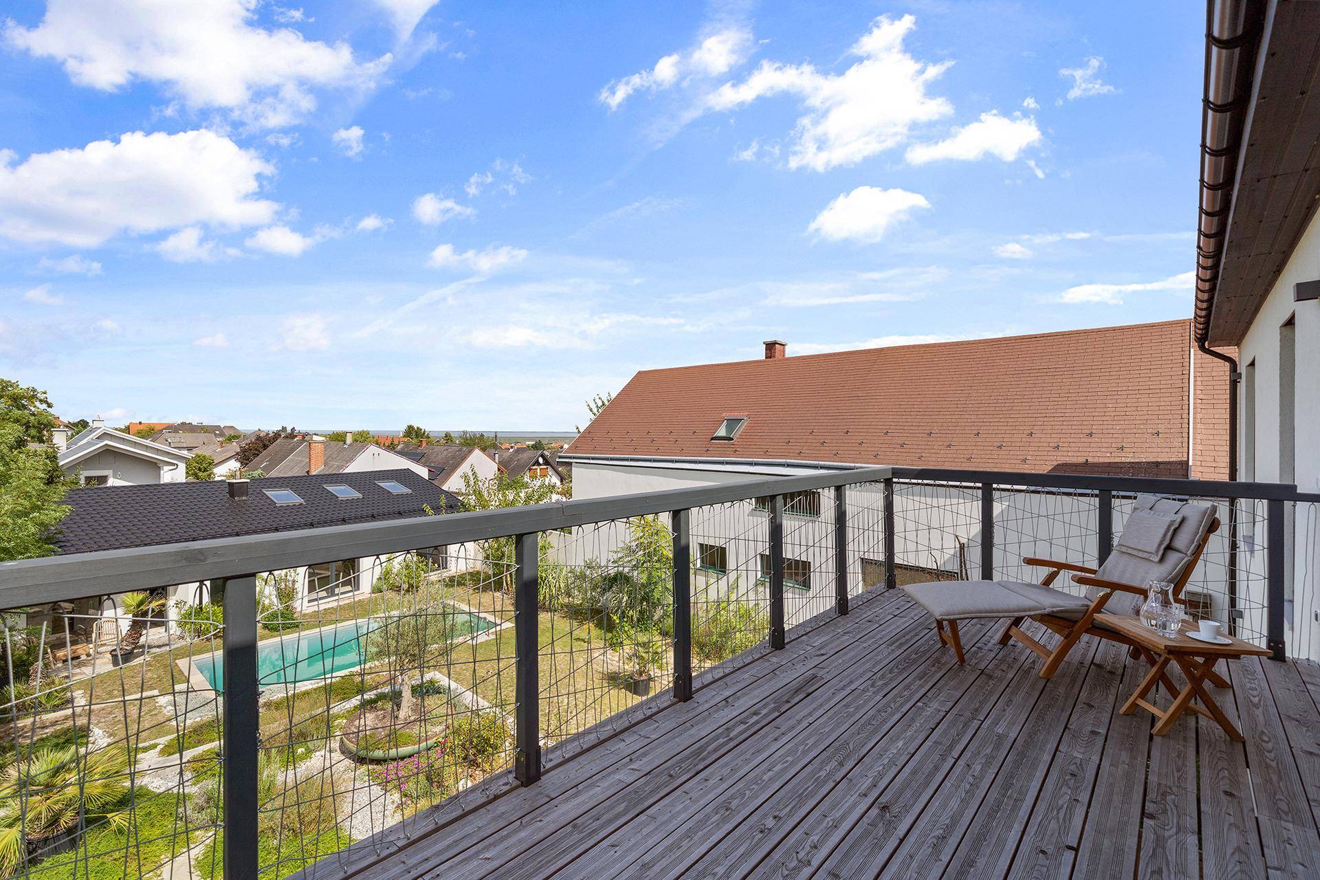 Großer Holzbalkon mit Sitzgelegenheiten und weitem Blick über die Umgebung.