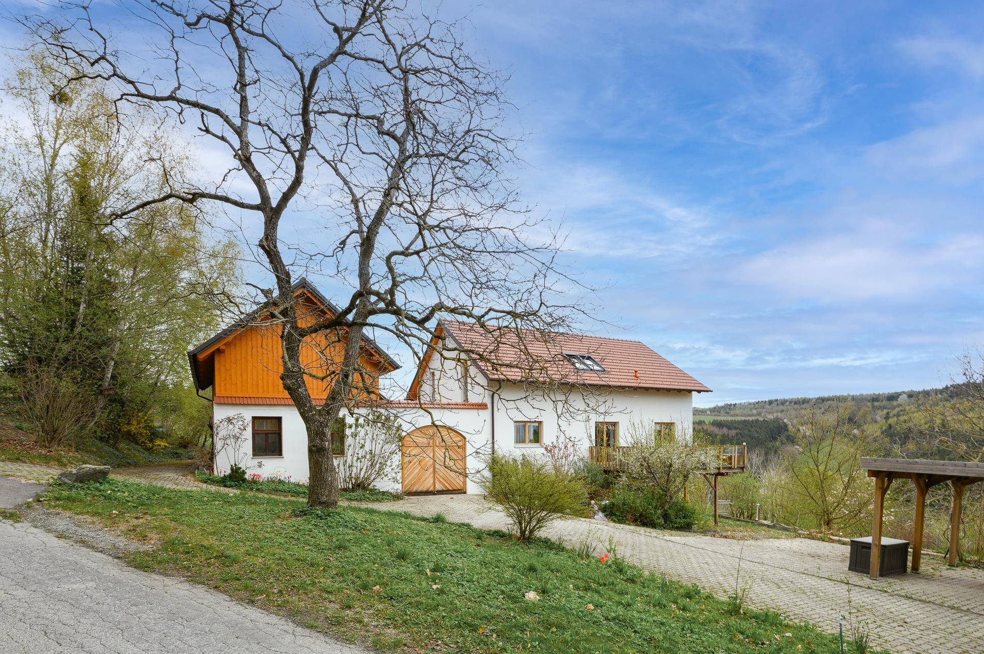 Landhaus mit traditioneller Architektur und weitem Blick über die grüne Landschaft.