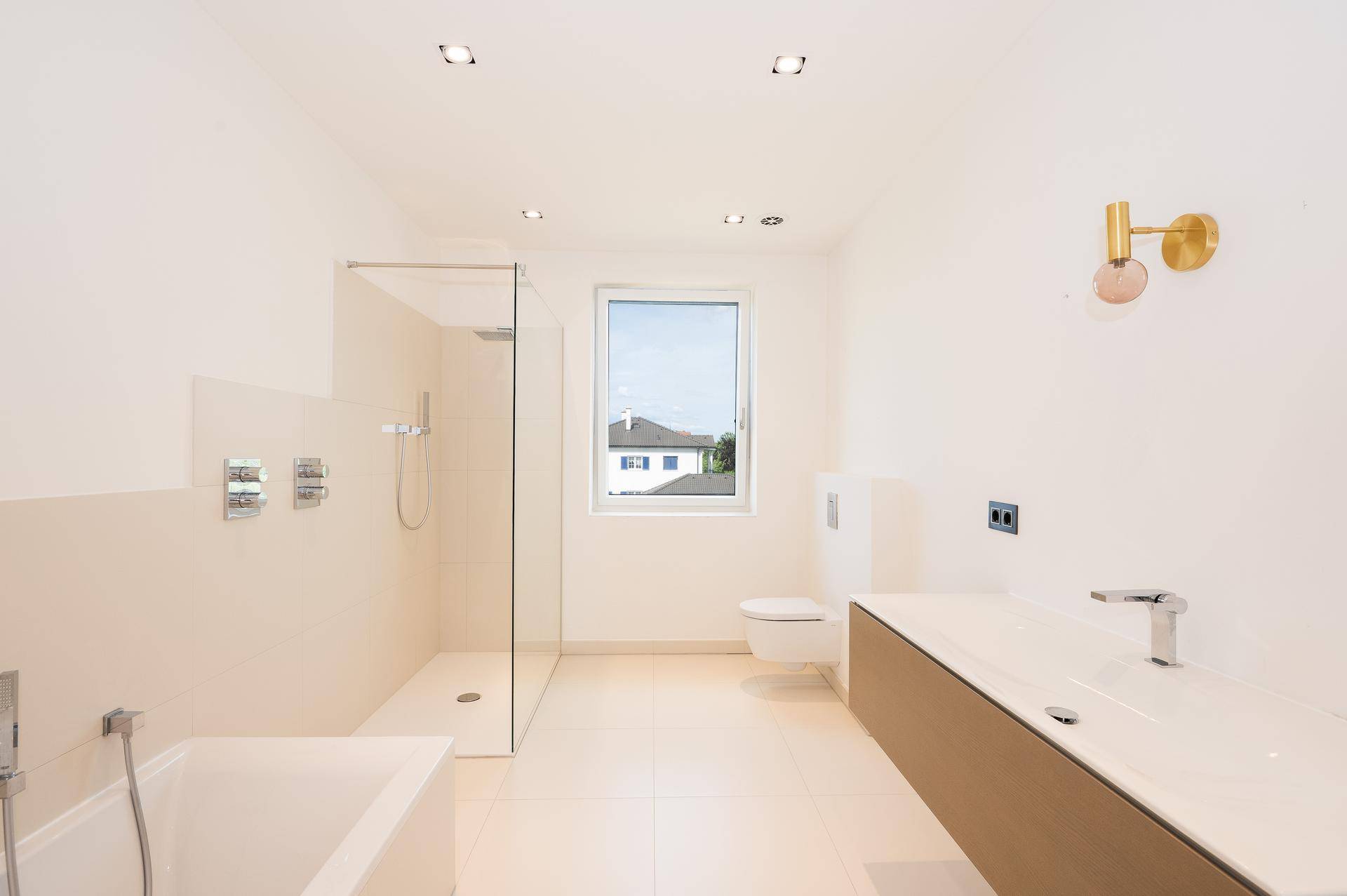 Modernes Badezimmer mit begehbarer Dusche, Badewanne, Wand-WC und schwebendem Waschtisch.