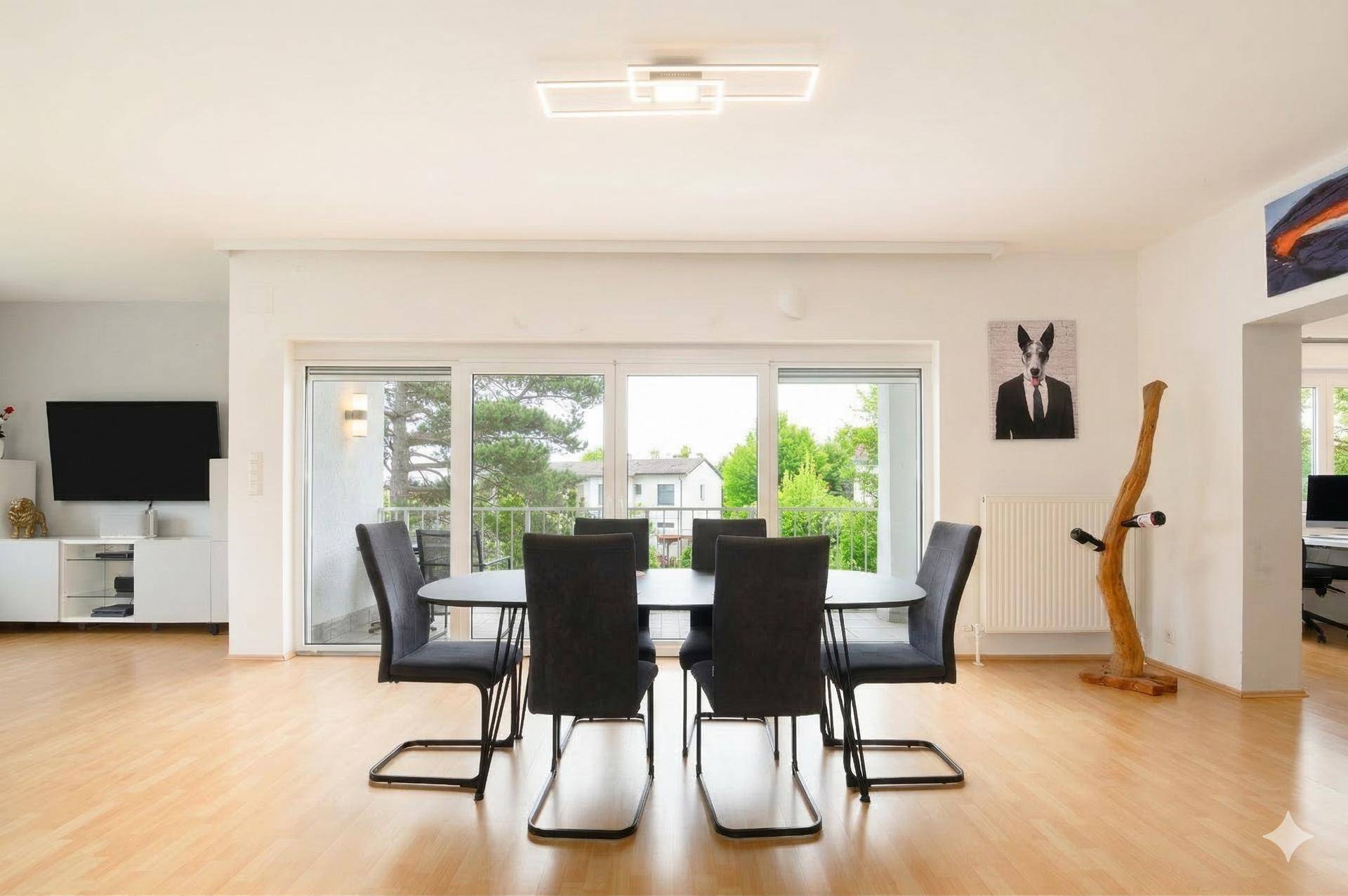 Heller Essbereich mit modernem Esstisch, Stühlen und Zugang zu einem Balkon.