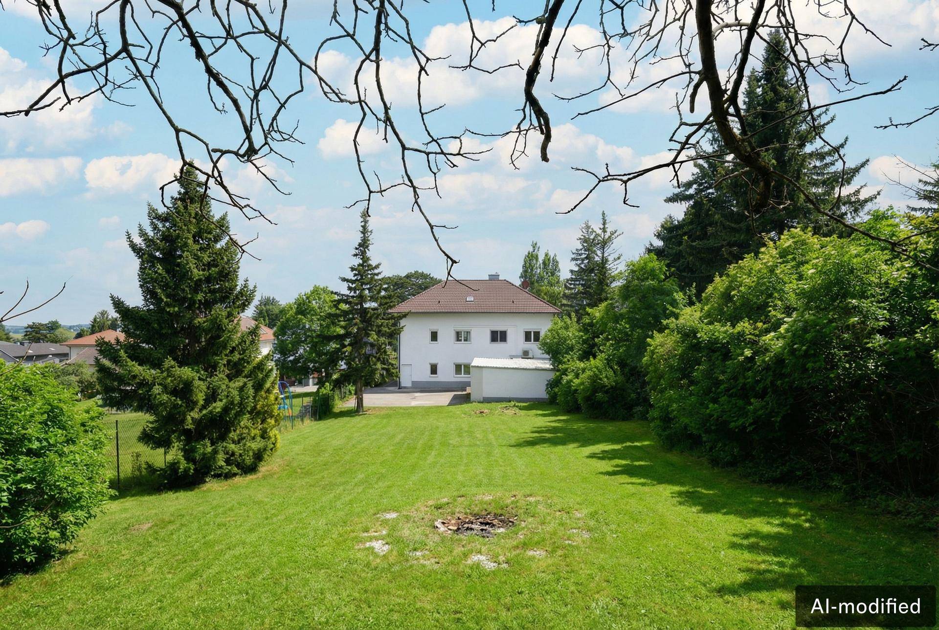 Weitläufiger Garten mit Rasenfläche, Bäumen und Blick auf das Wohnhaus.