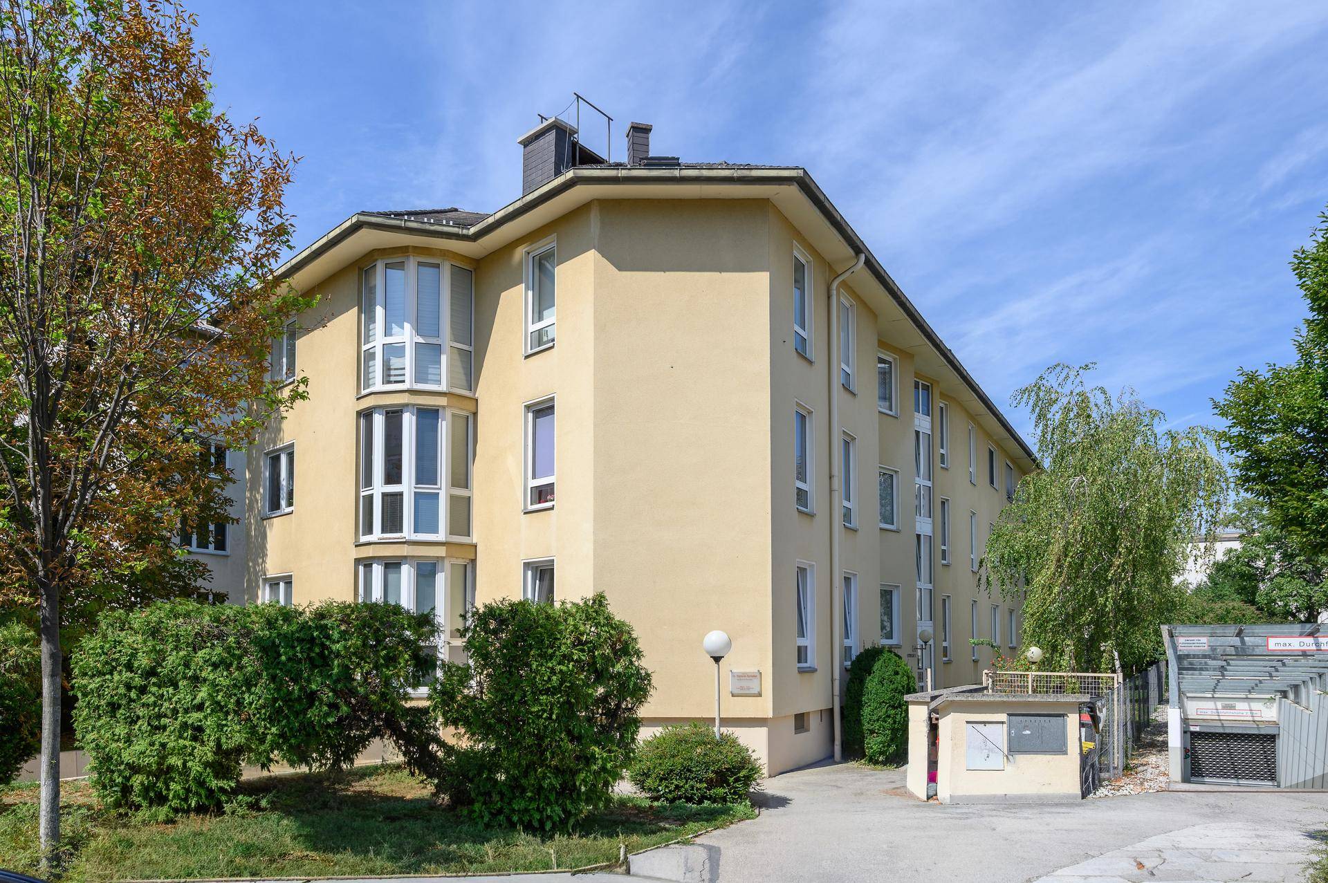 Außenansicht des Mehrfamilienhauses mit gepflegter Fassade und Grünflächen.