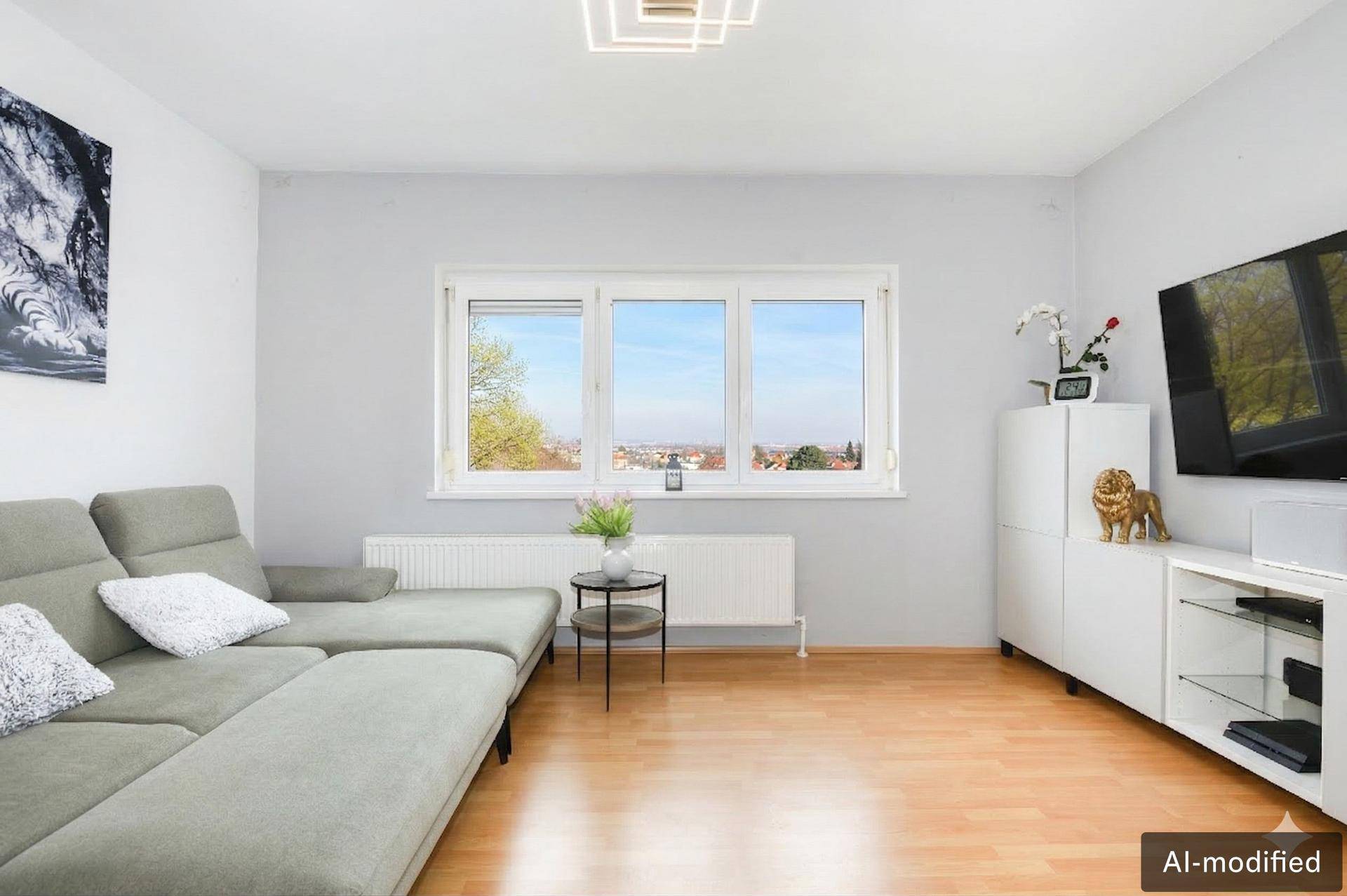 Helles Wohnzimmer mit Ecksofa, Holzboden und weitem Blick über die Stadt.