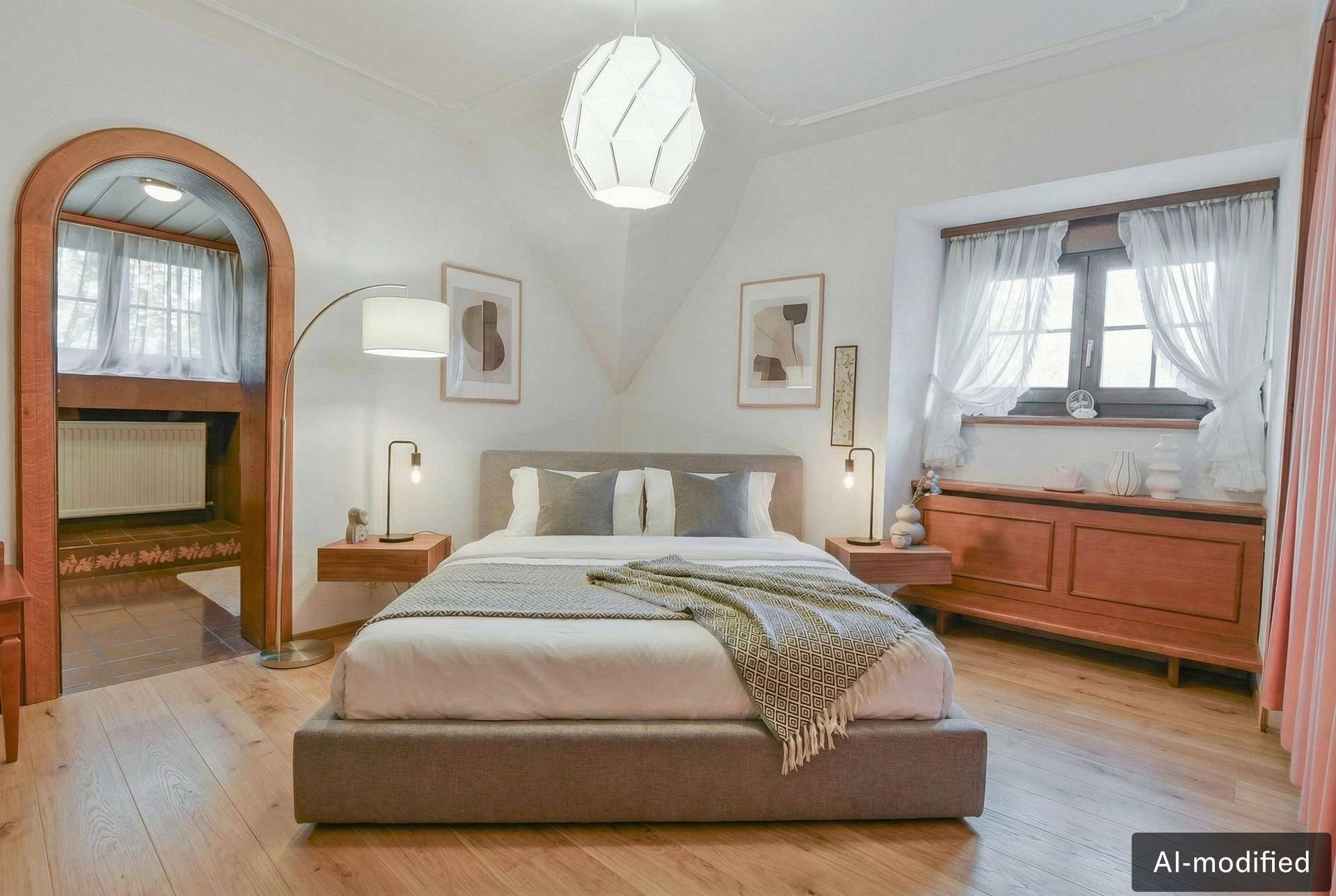 Modernisiertes Schlafzimmer mit stilvollem Bett und heller Gestaltung, unter einer Dachschräge mit Holzboden.