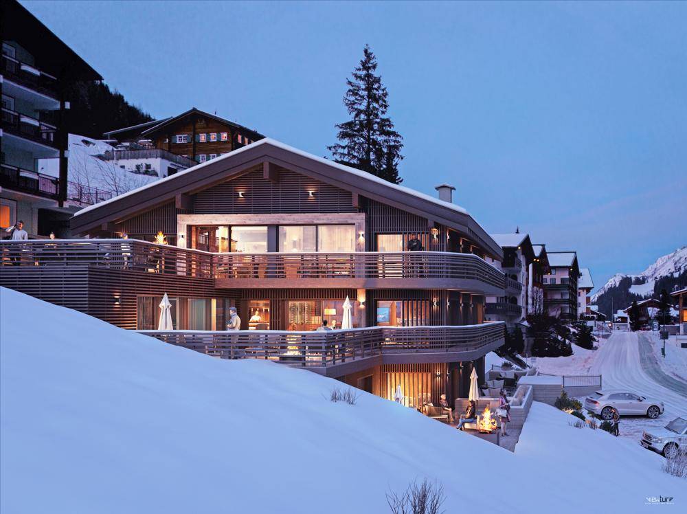 Attraktives Gebäude in alpiner Winterlandschaft mit mehreren Balkonen und Terrassen, harmonisch in die Natur integriert.