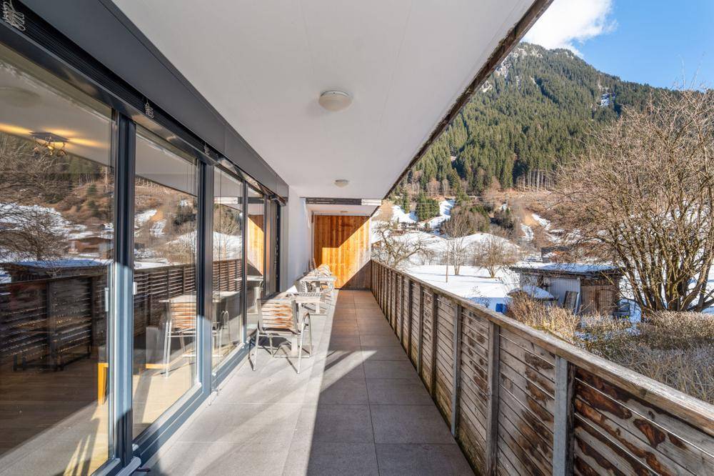 Geräumiger Balkon mit Sitzgelegenheiten und weitem Blick auf die Berge.