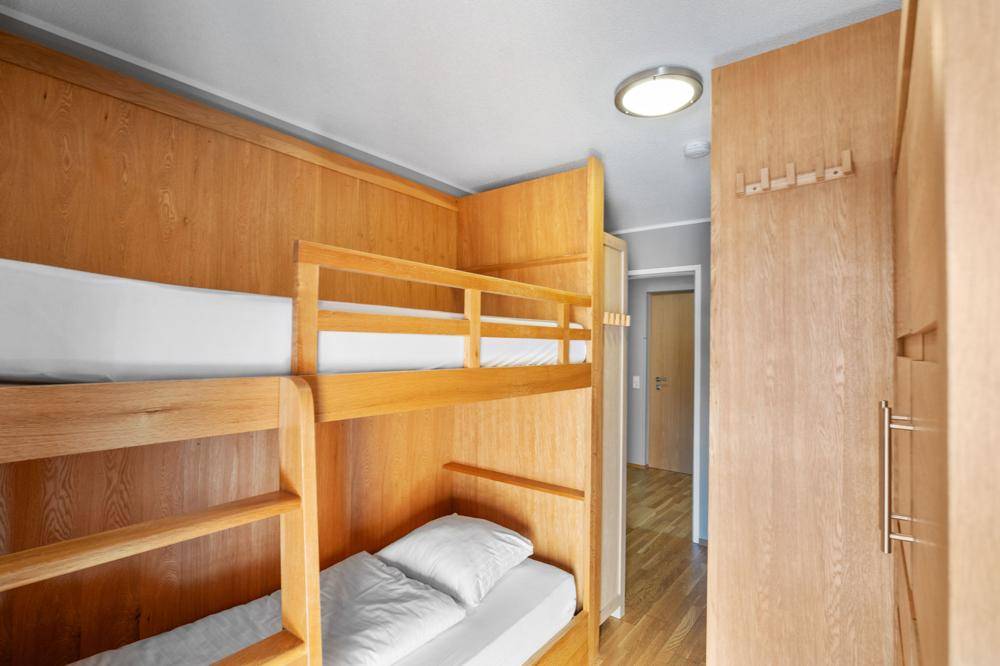 Kinderzimmer mit Etagenbetten aus Holz und Holzwänden, ideal für Familien.