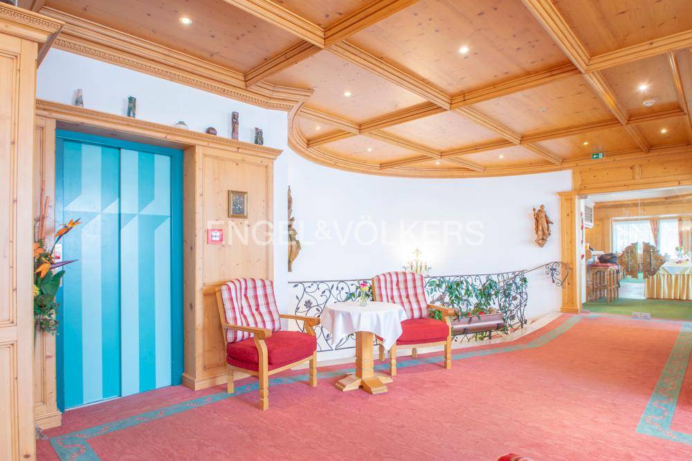 Gemütlicher Loungebereich im Hotel mit Aufzug, Teppichboden und traditionellen Sitzgelegenheiten.