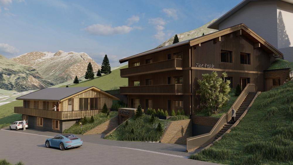 Attraktive Gebäude in moderner alpiner Architektur, eingebettet in eine grüne Berglandschaft, mit Parkmöglichkeiten.