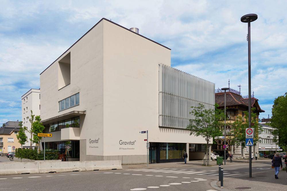 Ansicht des modernen Bürogebäudes "Gravitat" mit heller Fassade und strukturierten Fensterfronten.