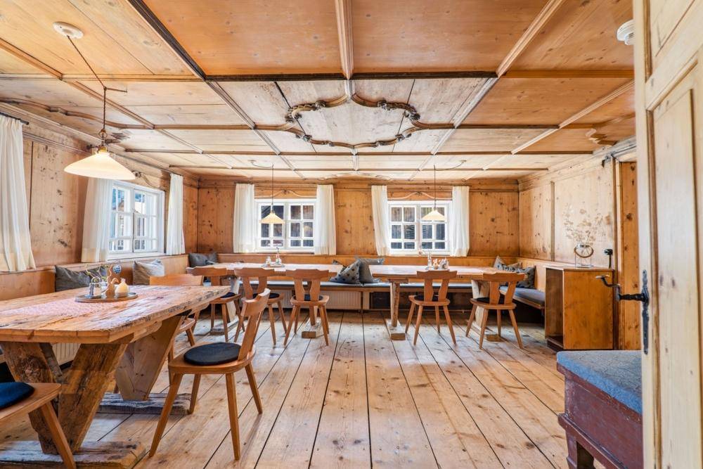Rustikaler Essbereich mit massiven Holztischen, Holzböden und traditioneller Holzdecke.