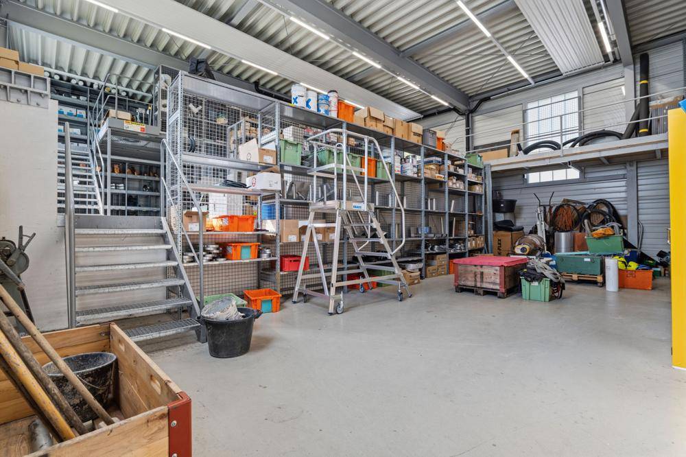 Lagerhalle mit hohen Regalsystemen, Treppen und verschiedenen Materialien.