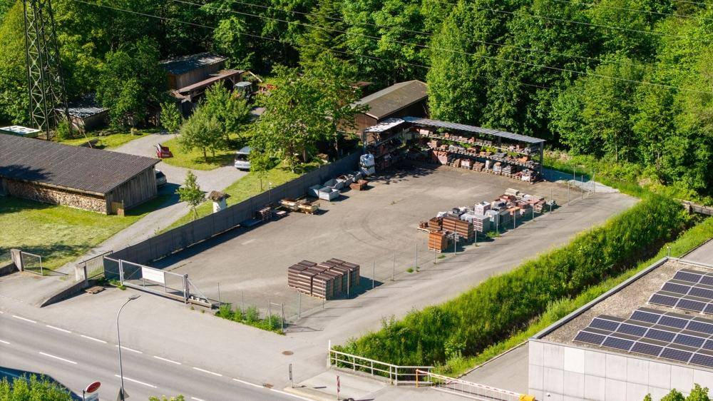 Luftaufnahme eines Freilagers mit Baumaterialien und angrenzender Straße.