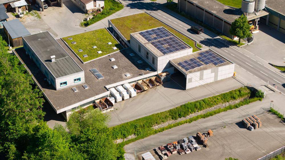 Luftaufnahme des Gewerbekomplexes mit mehreren Gebäuden, Gründächern und Solaranlagen.