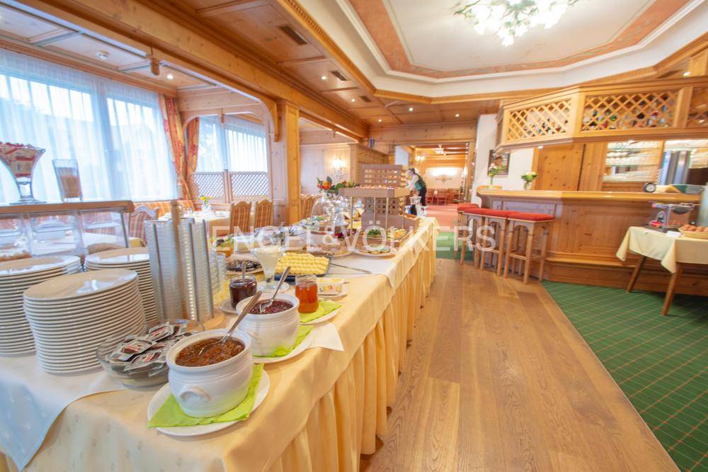 Traditioneller Frühstücksbereich mit Buffet, Holzelementen und Bar in einem gemütlichen Ambiente.