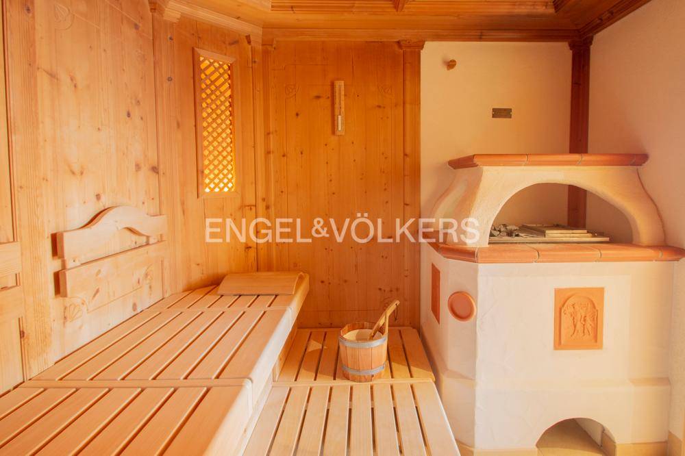 Traditionelle Holzsauna mit Liegebänken und einem gemauerten Ofen für entspannende Momente.