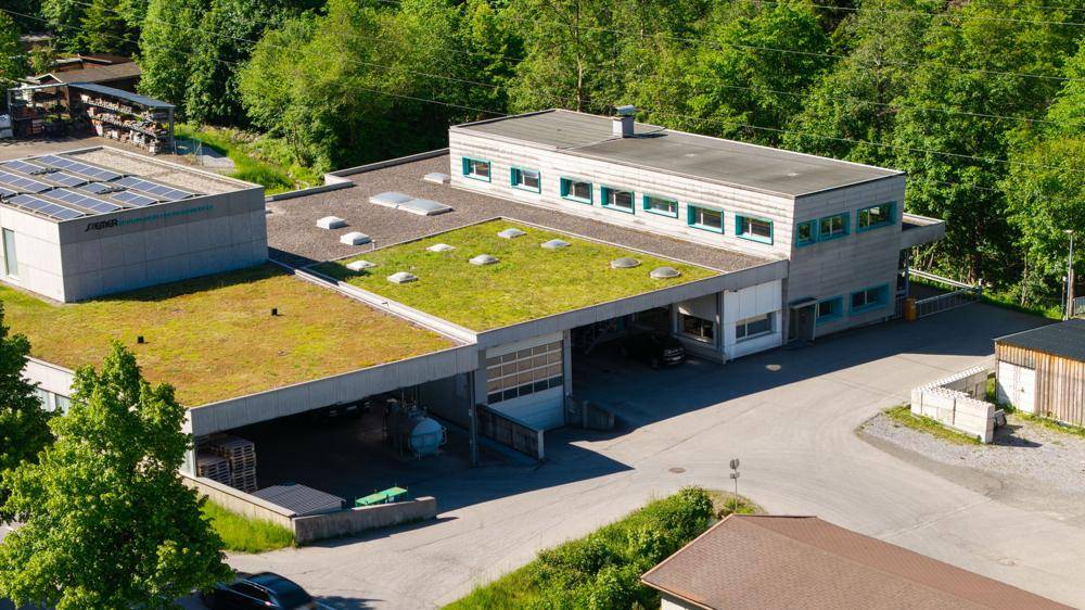 Luftaufnahme des Gewerbegebäudes mit begrünten Dächern und Flachdacharchitektur.