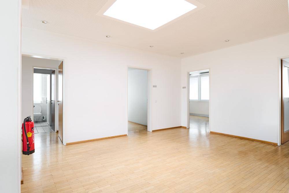Geräumiger Flur mit Parkettboden, mehreren Türen und einem Oberlicht, das für Helligkeit sorgt.