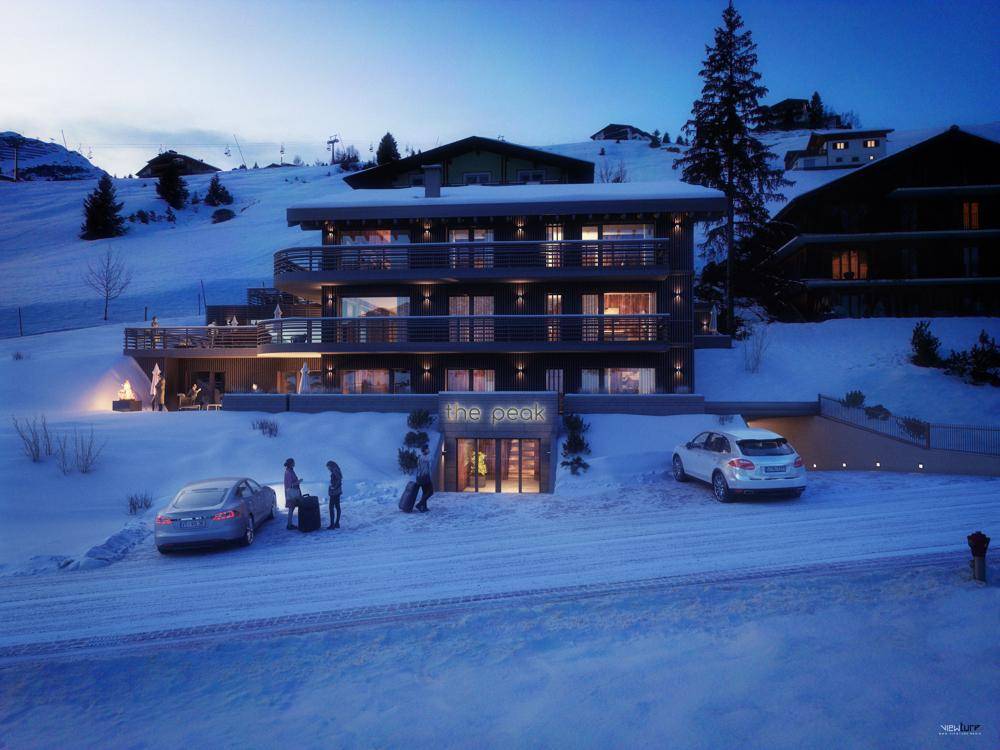 Modernes Gebäude in verschneiter Umgebung mit beleuchtetem Eingangsbereich und Parkplätzen, einladend und funktional.