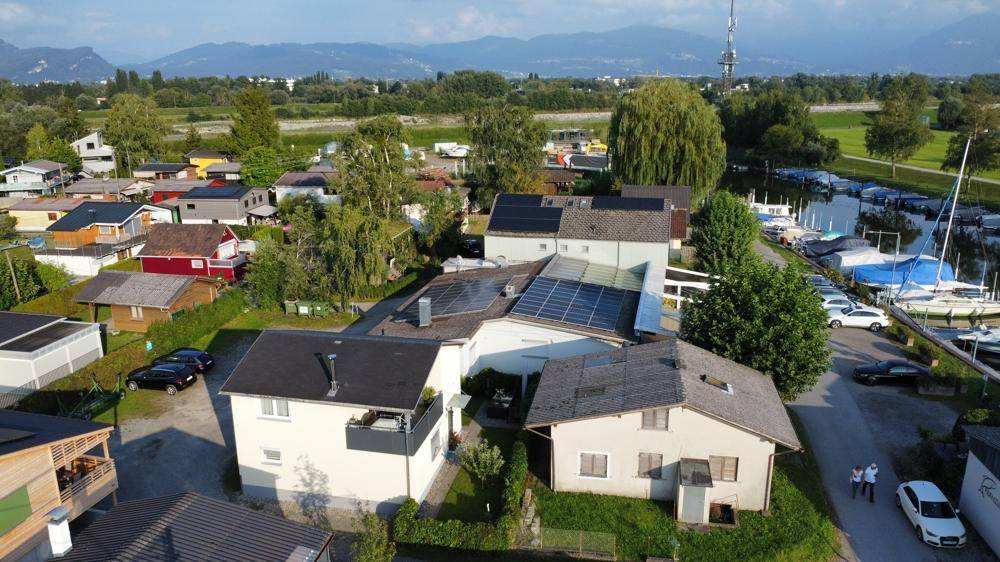 Luftaufnahme des Anwesens mit mehreren Gebäuden, Solaranlagen auf den Dächern und einem Yachthafen in der Nähe.