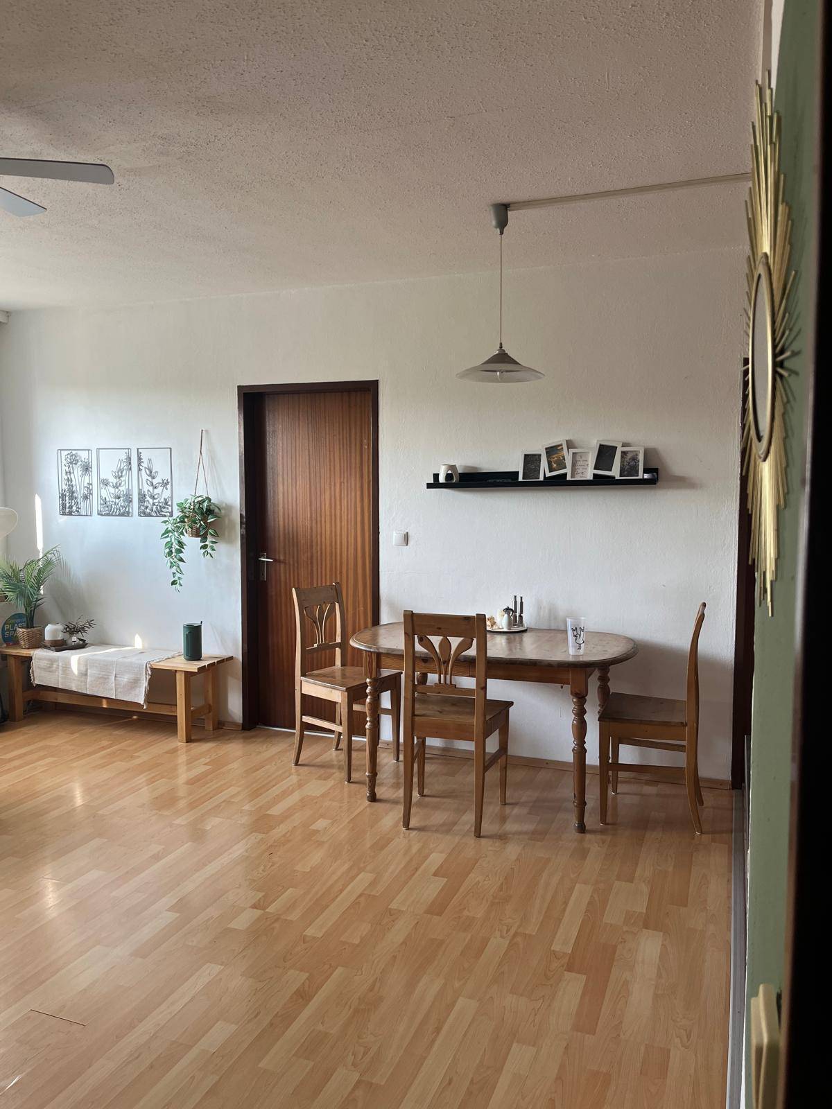 Heller Essbereich mit Holztisch und Stühlen, integriert in einen offenen Wohnraum.