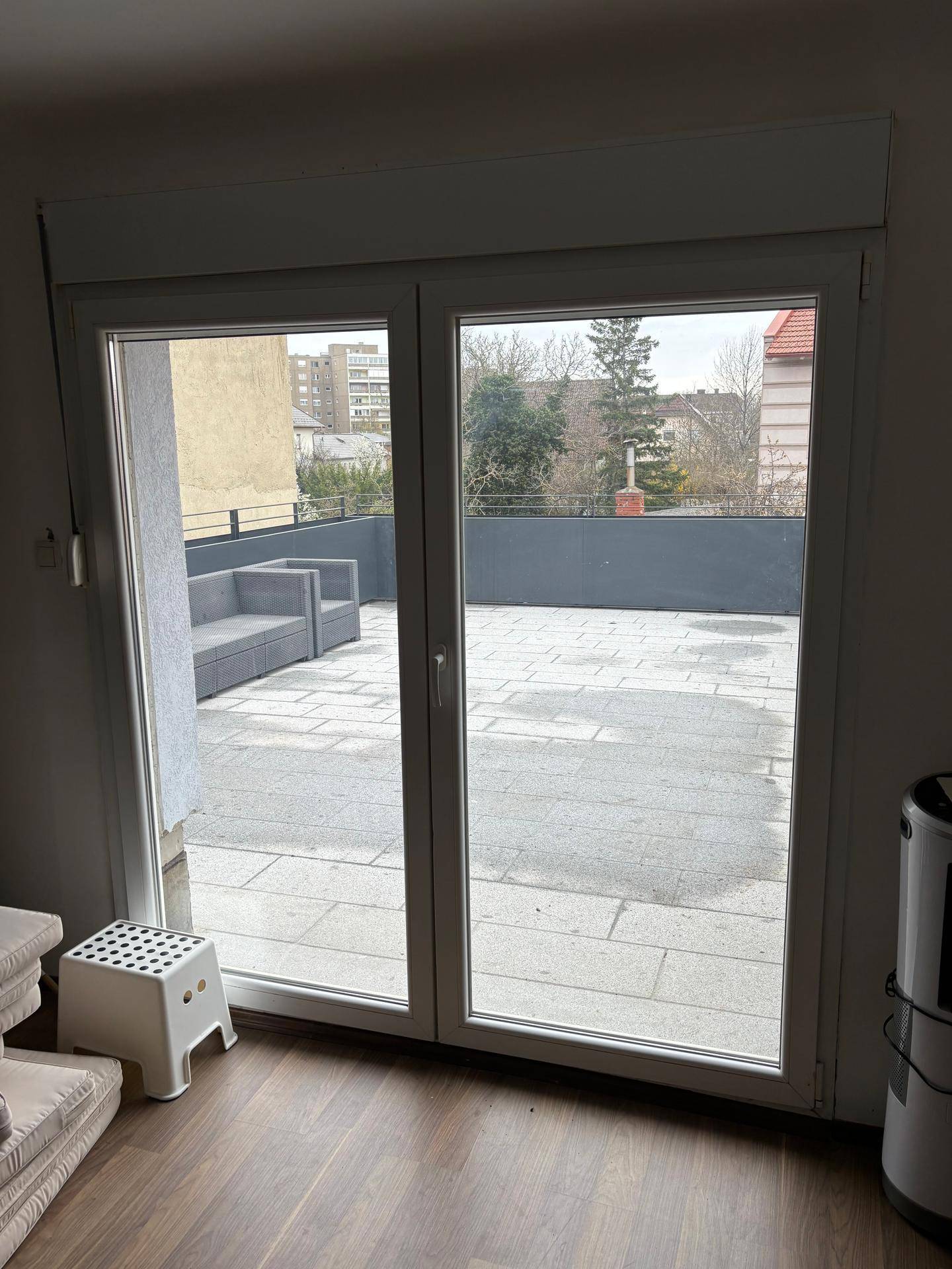 Große Terrassentür im Wohnzimmer, die viel Licht hereinlässt und Zugang zur Dachterrasse bietet.