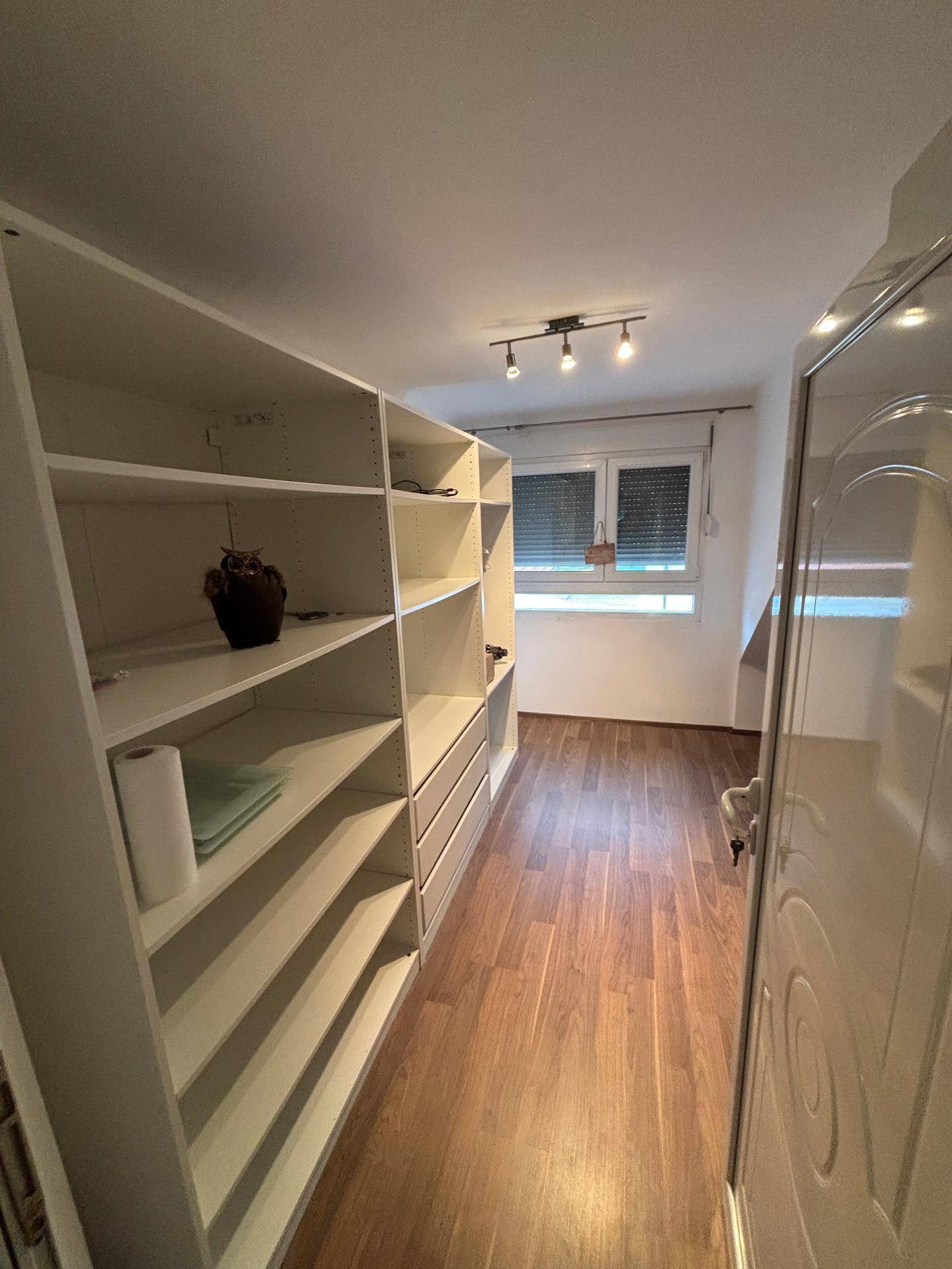 Begehbarer Kleiderschrank mit vielen Regalen und Stauraum, gut organisiert.