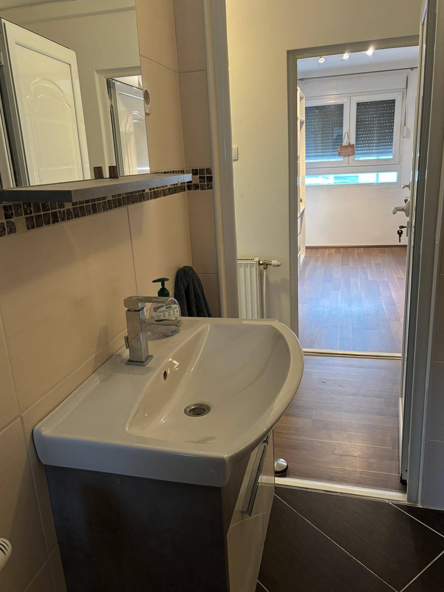 Waschtisch im Badezimmer mit Blick auf den angrenzenden begehbaren Kleiderschrank.