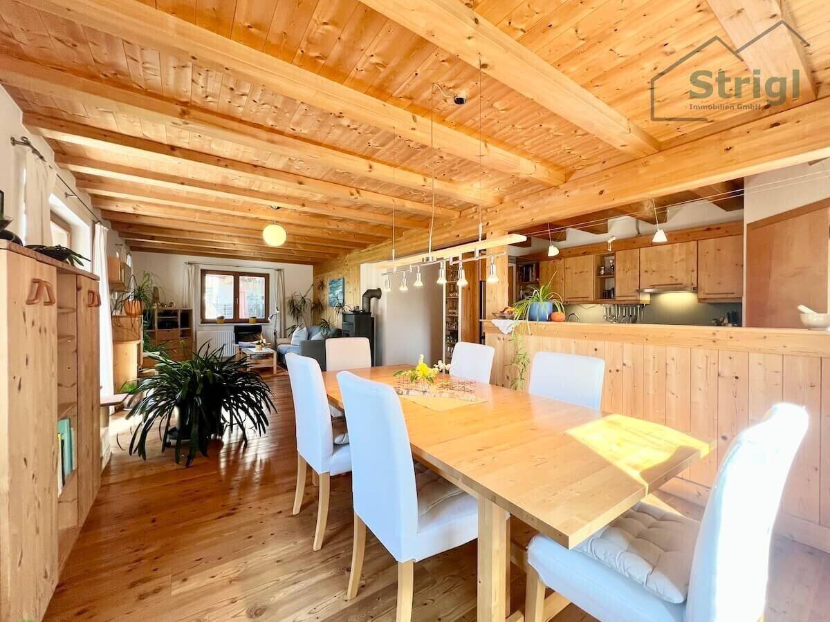 Geräumiger Essbereich mit Holztisch, bequemen Stühlen und offenem Zugang zu Wohnzimmer und Küche.