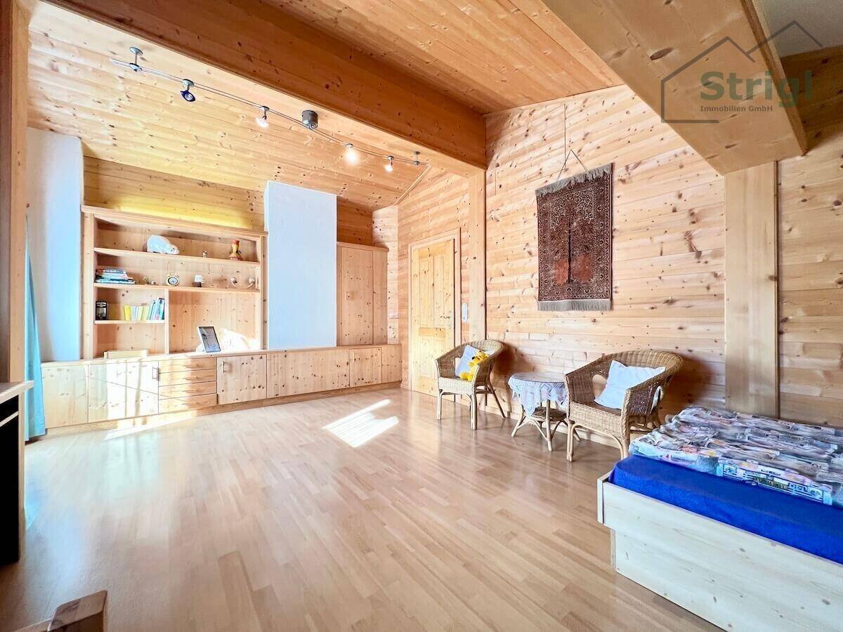 Helles Schlafzimmer mit Holzwänden, integrierten Einbauschränken und einem Holzboden.