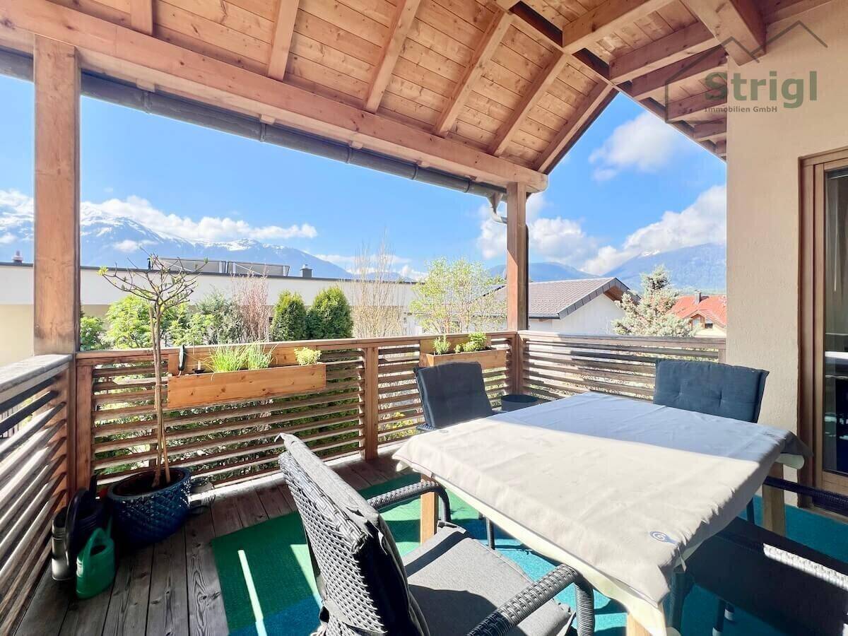 Überdachter Balkon mit Sitzgelegenheiten und herrlichem Panoramablick auf die umliegenden Berge.