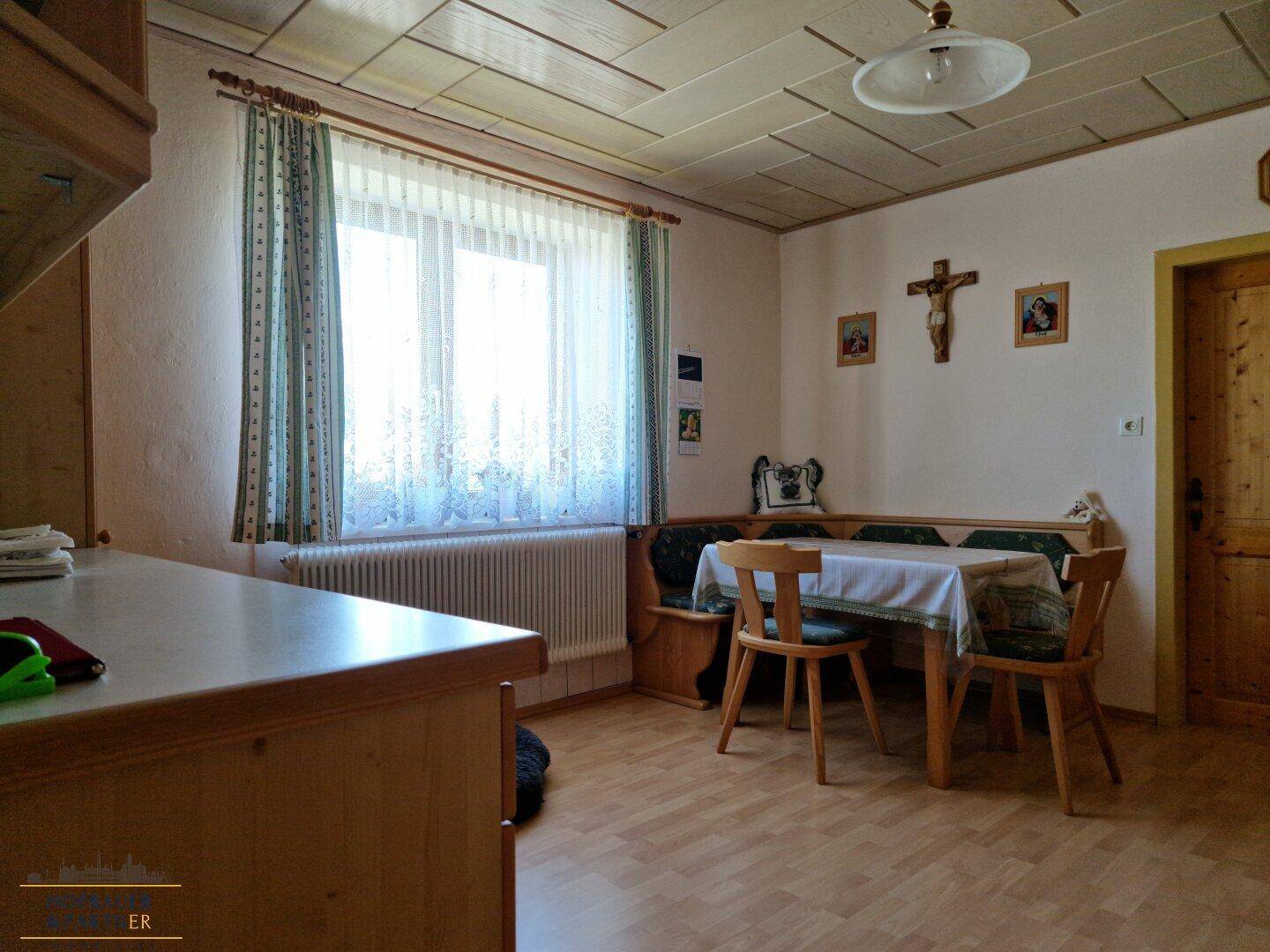 Heller Essbereich in der Küche mit Eckbank, Holztisch und Blick ins Grüne.