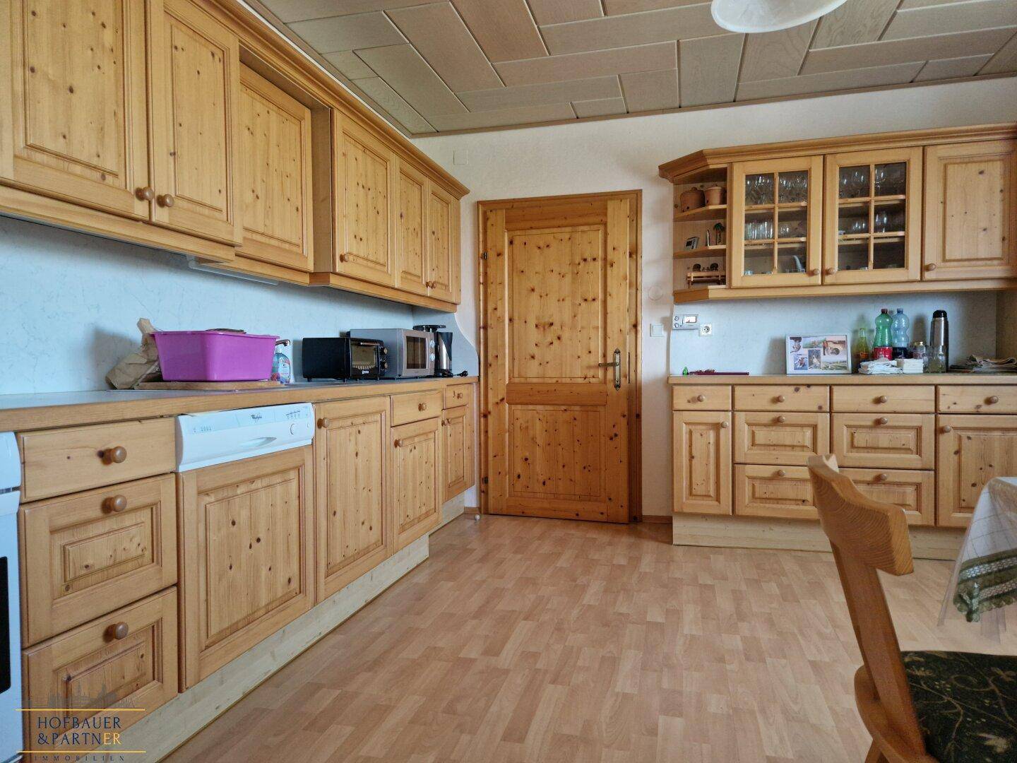 Rustikale Küche mit Holzfronten, integrierten Geräten und Essbereich.