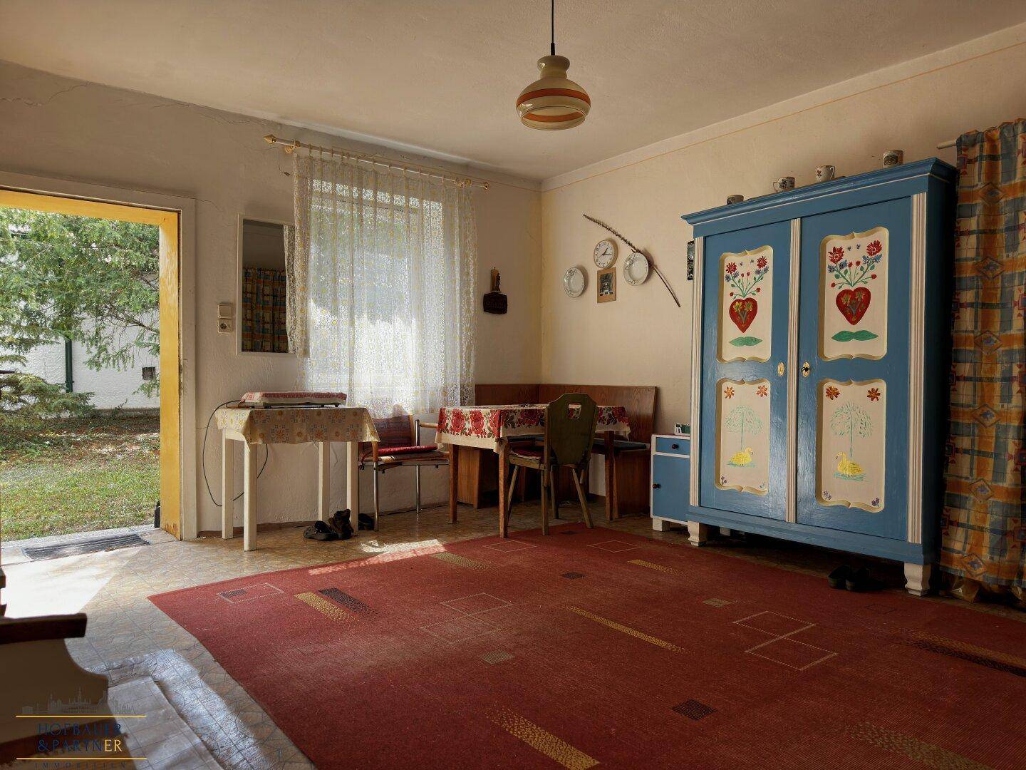 Rustikaler Mehrzweckraum mit traditionellem Schrank, Teppichboden und direktem Zugang zum Garten.