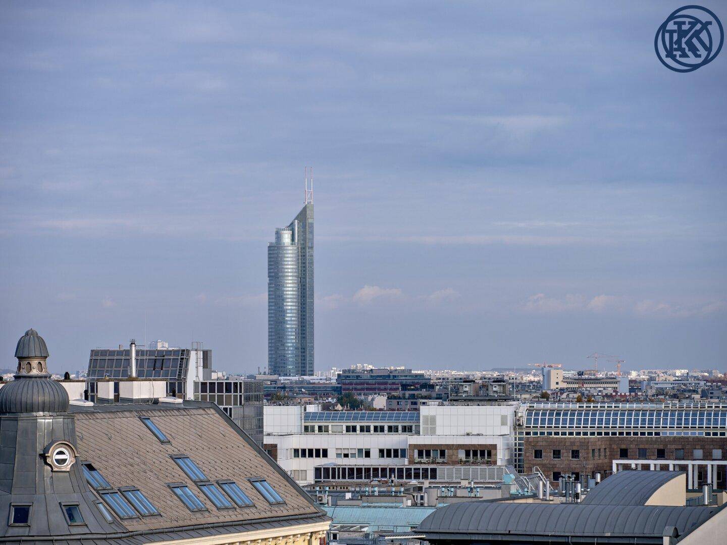 Panoramablick über die Stadt mit einem markanten Hochhaus am Horizont.