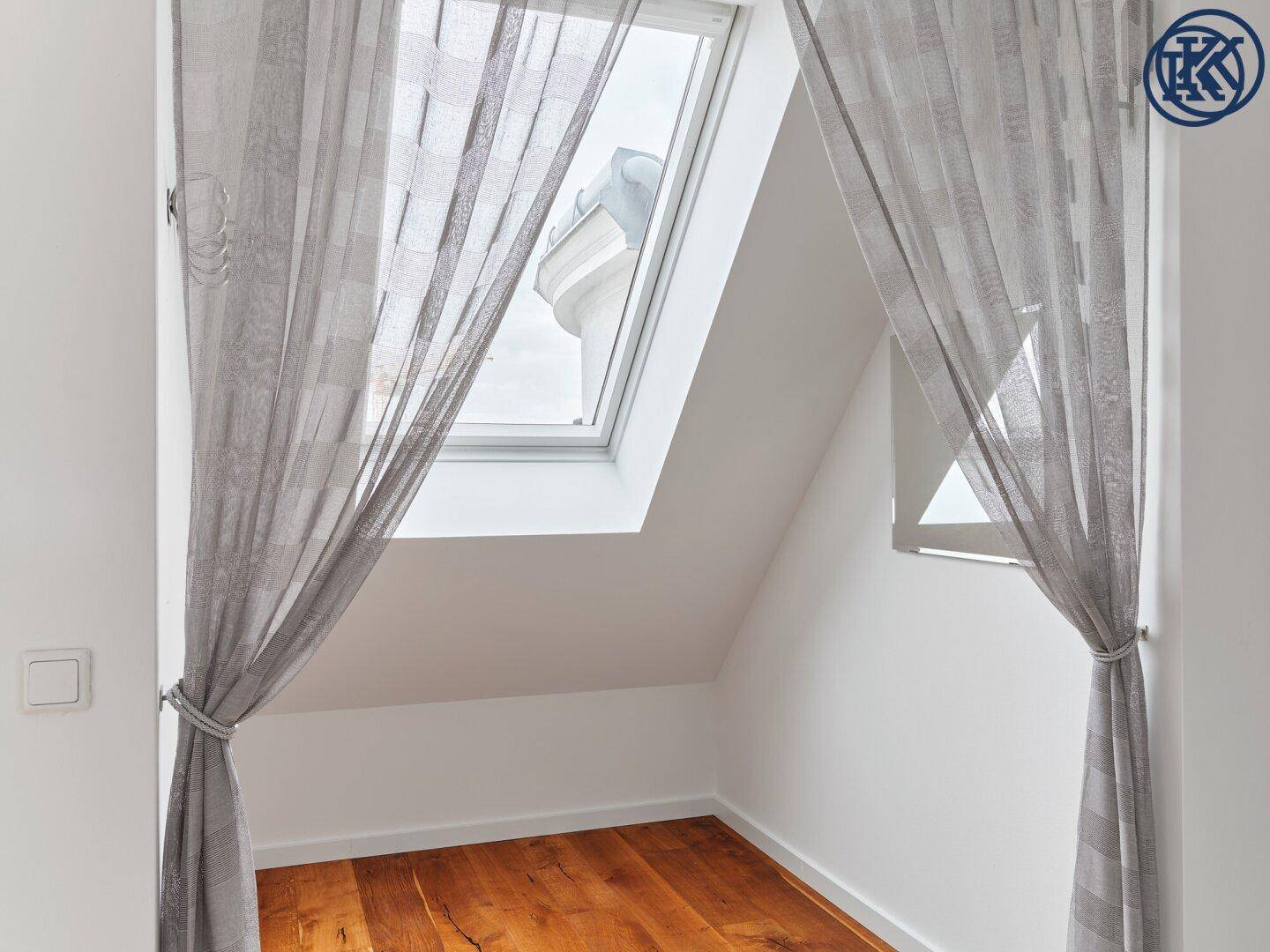 Gemütliche Nische mit Holzboden und einem Dachfenster, das viel Tageslicht hereinlässt.
