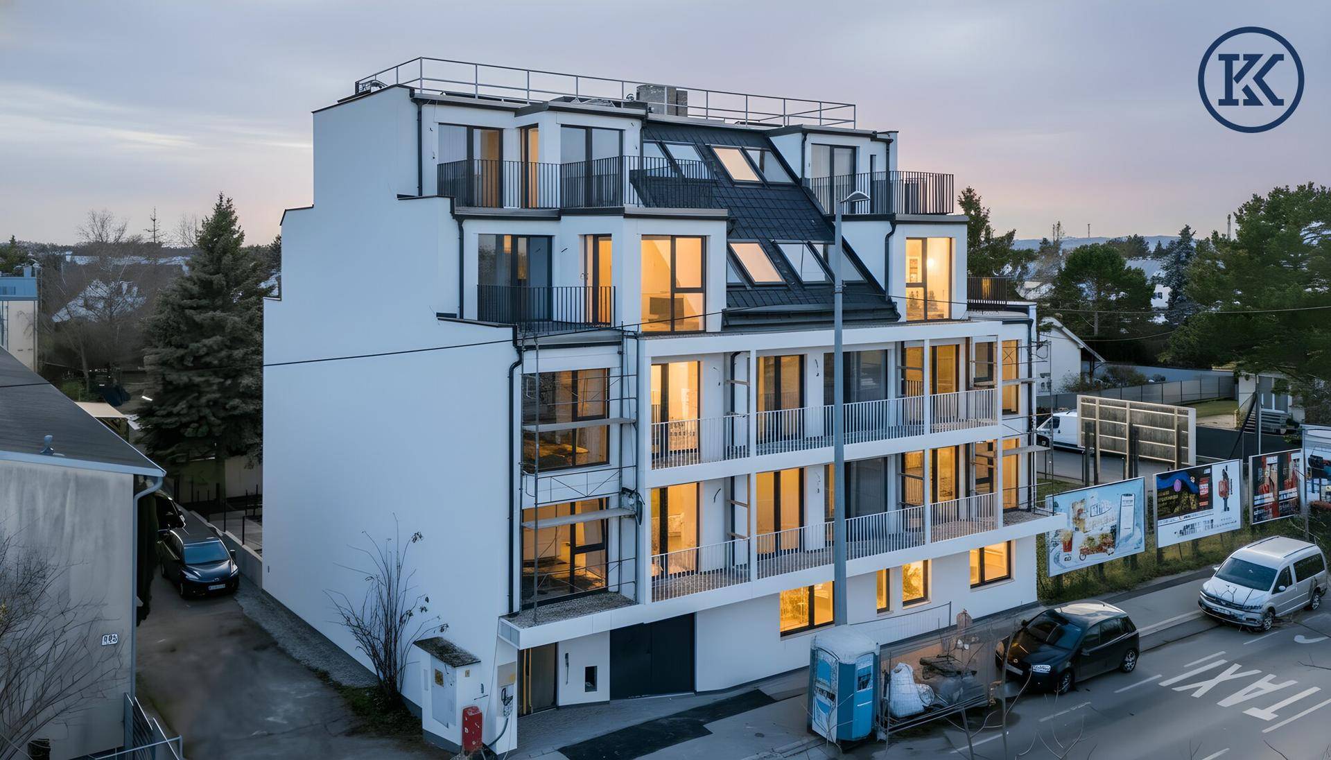 Neubau-Mehrfamilienhaus mit moderner Architektur, vielen Balkonen und großen Fensterfronten.