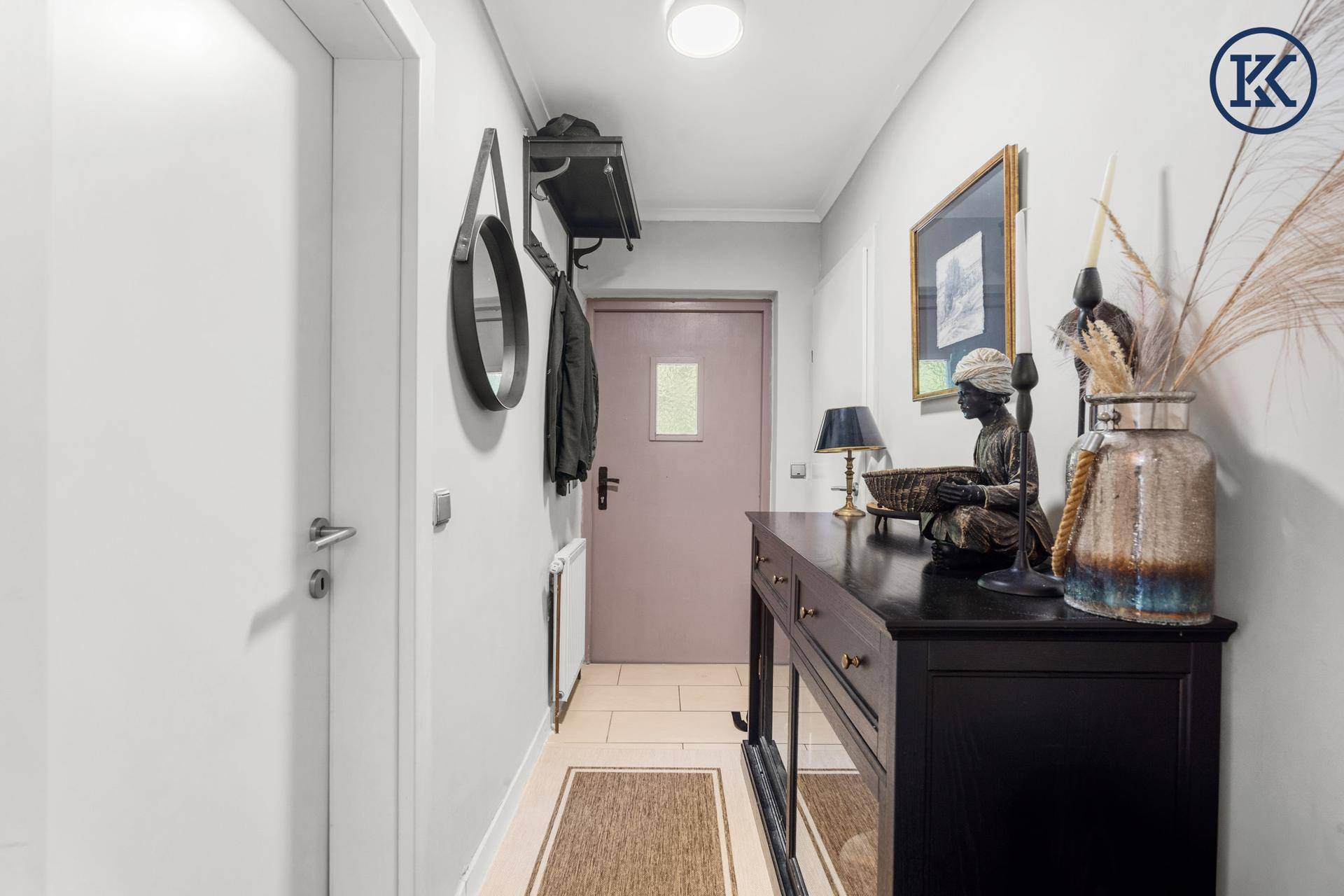 Heller Flur mit stilvoller Konsole, Spiegel und Garderobe, einladend gestaltet.
