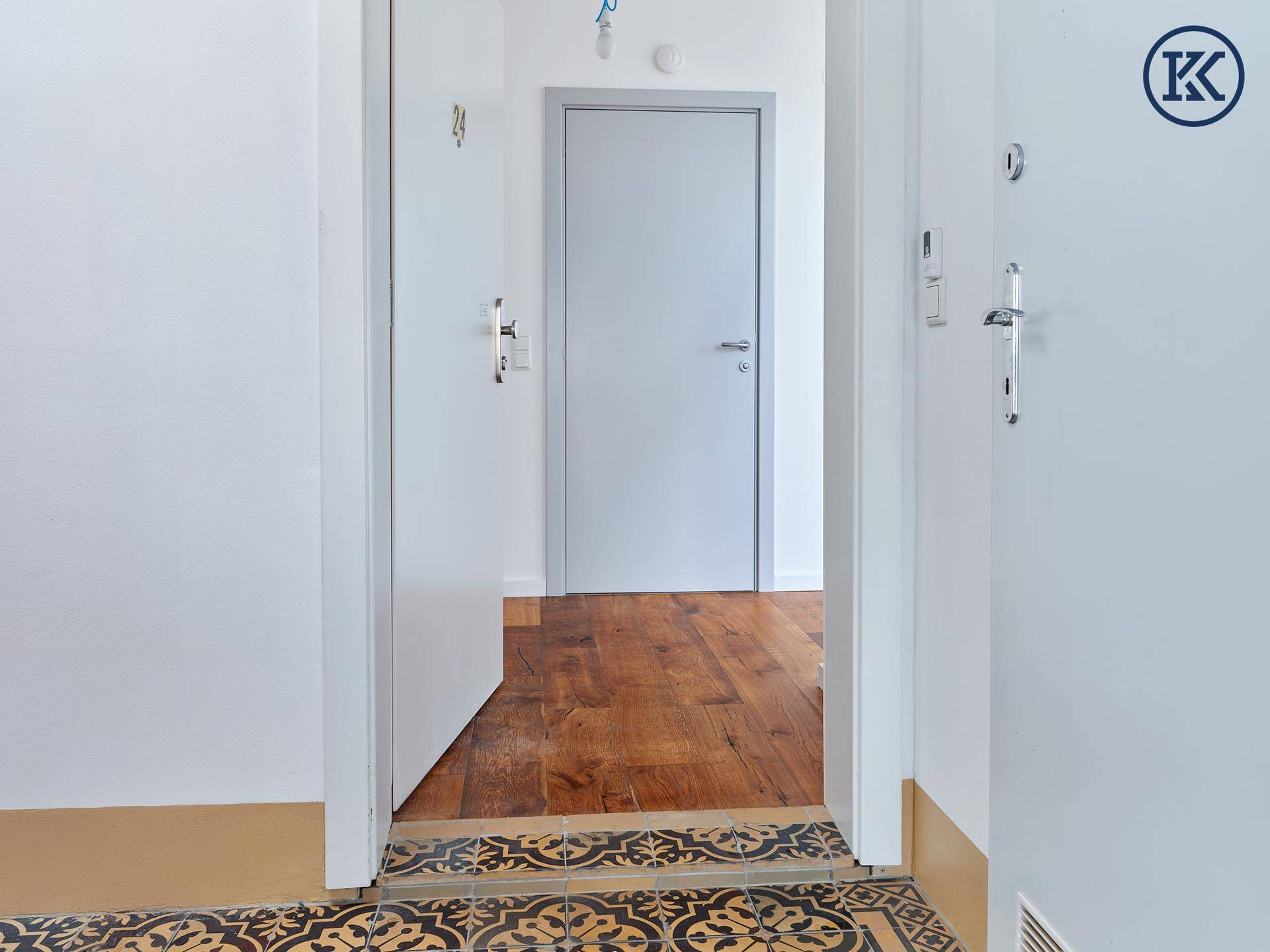Heller Flur mit Holzboden und Zugang zu verschiedenen Zimmern der Wohnung.