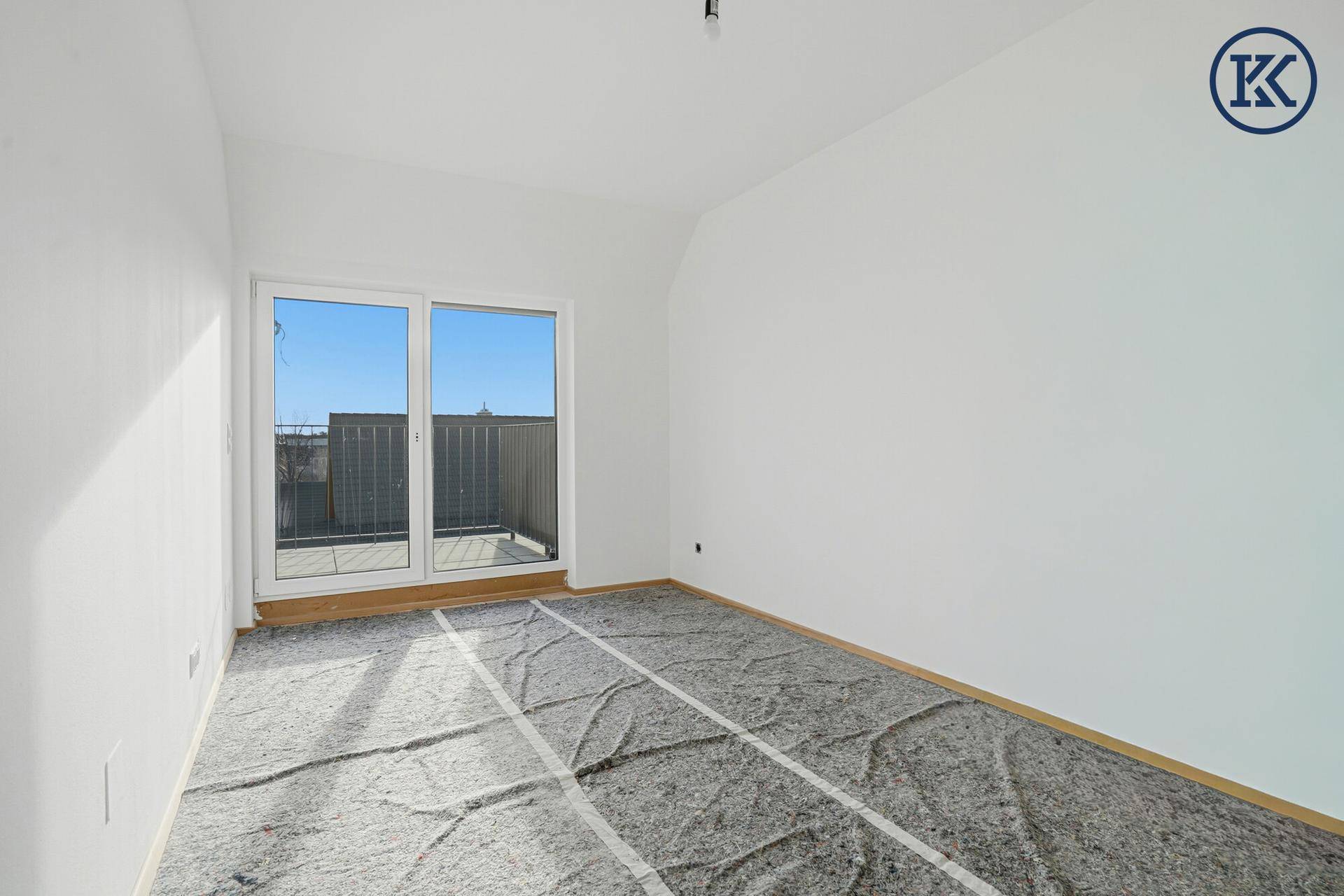 Heller, unfertiger Raum mit Zugang zu einem Balkon, bereit für die individuelle Gestaltung.
