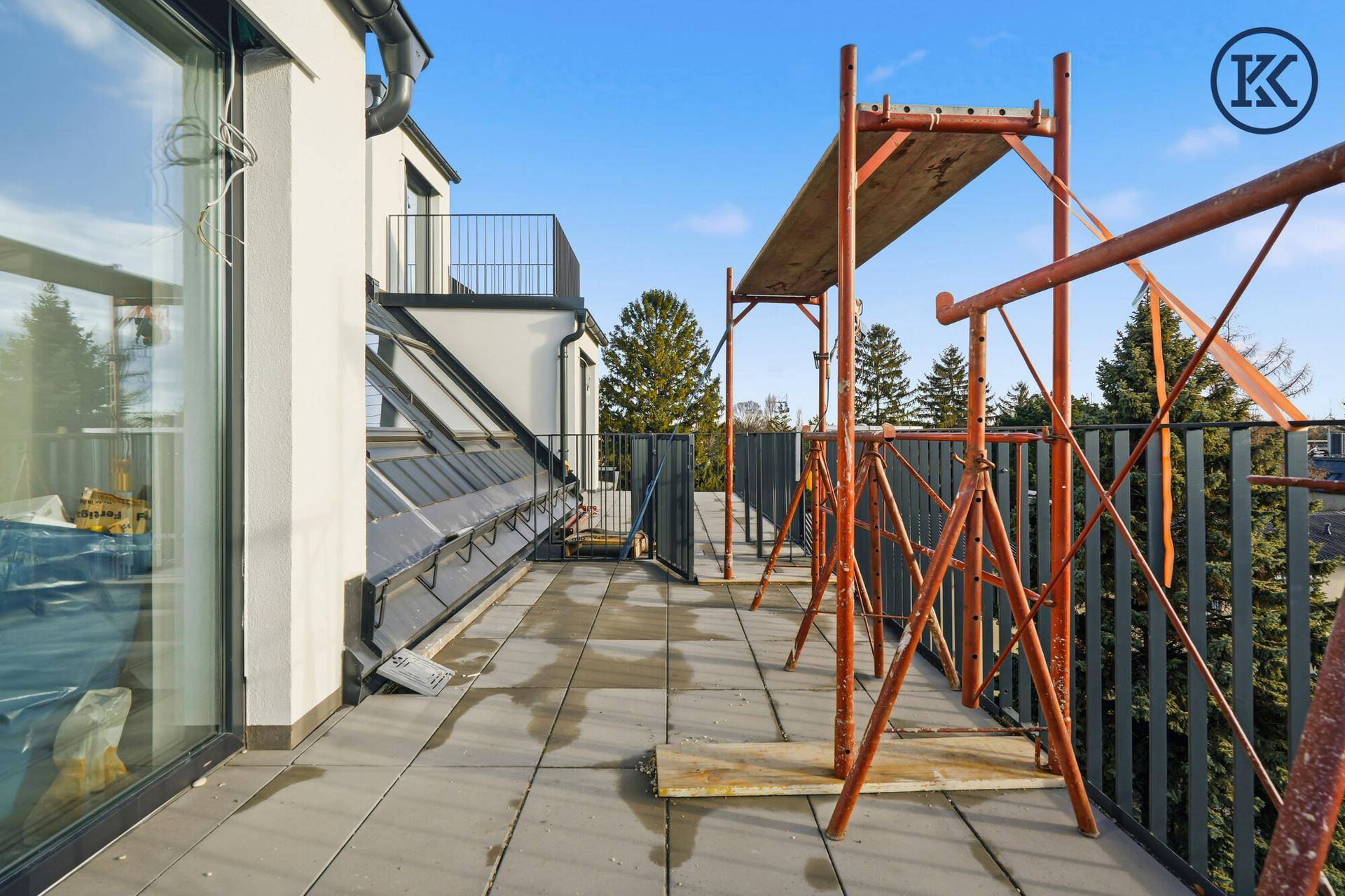 Weitläufiger Balkon mit Fliesen und Baugerüst, bietet einen Panoramablick über die Stadt.