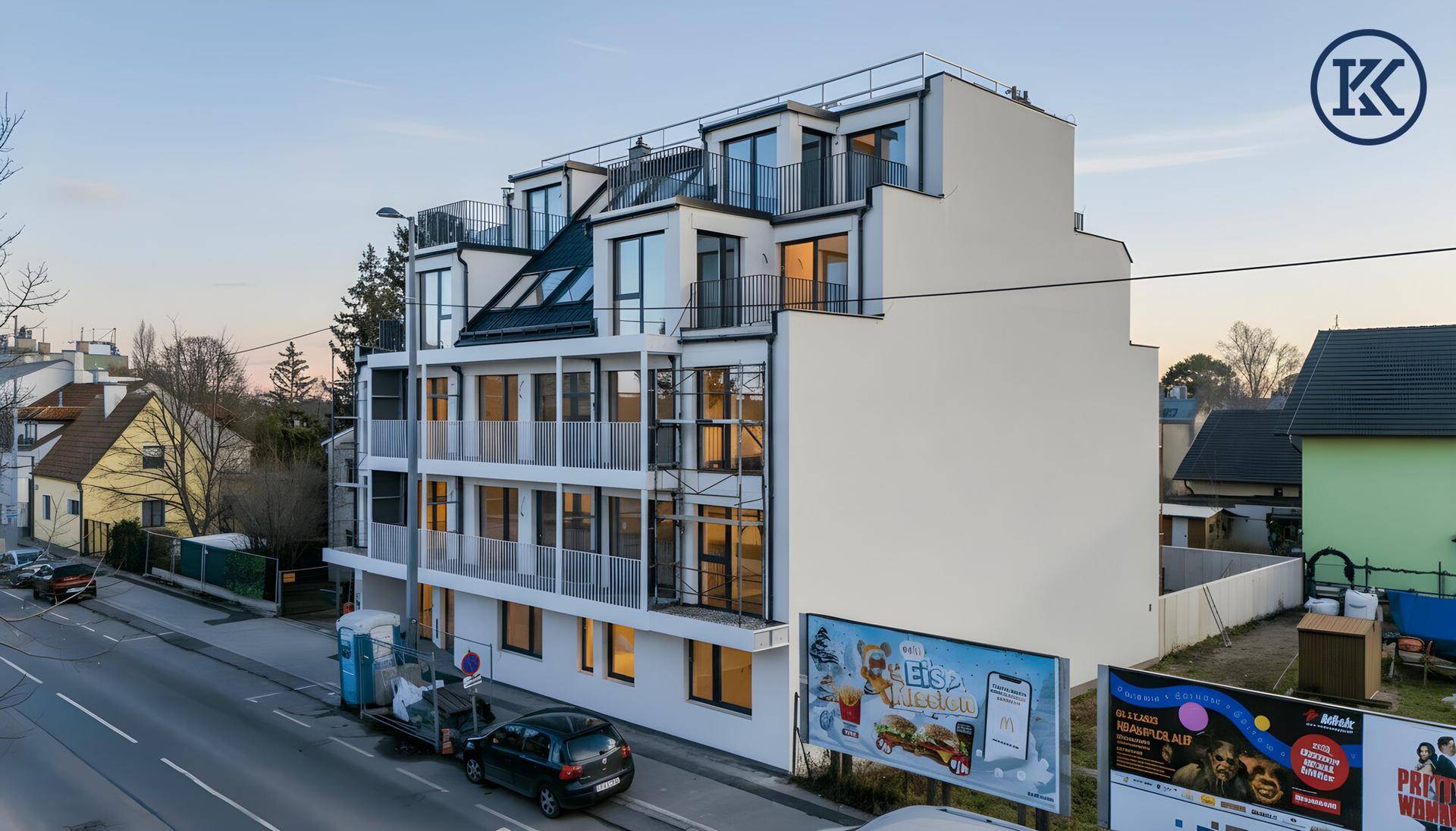 Modernes Wohngebäude von der Straße aus gesehen, mit Balkonen und großen Fenstern.