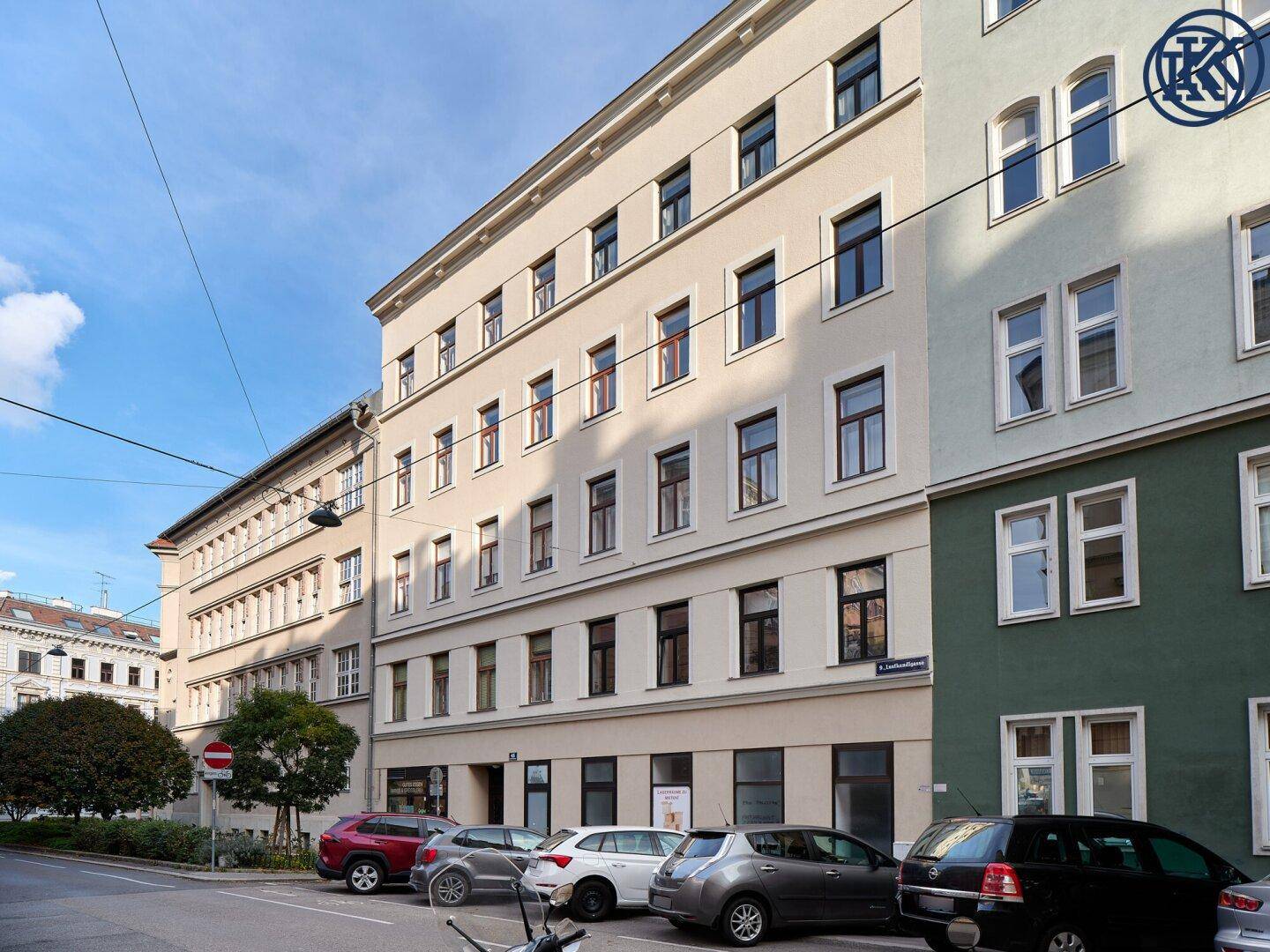 Mehrstöckiges Wohngebäude mit klassischer Fassade und vielen Fenstern an einer städtischen Straße.