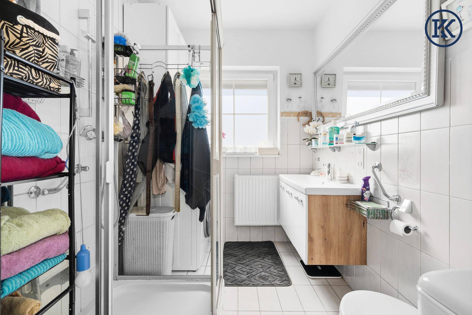 Modernes Badezimmer mit Dusche, Waschbecken und Fenster für Tageslicht.