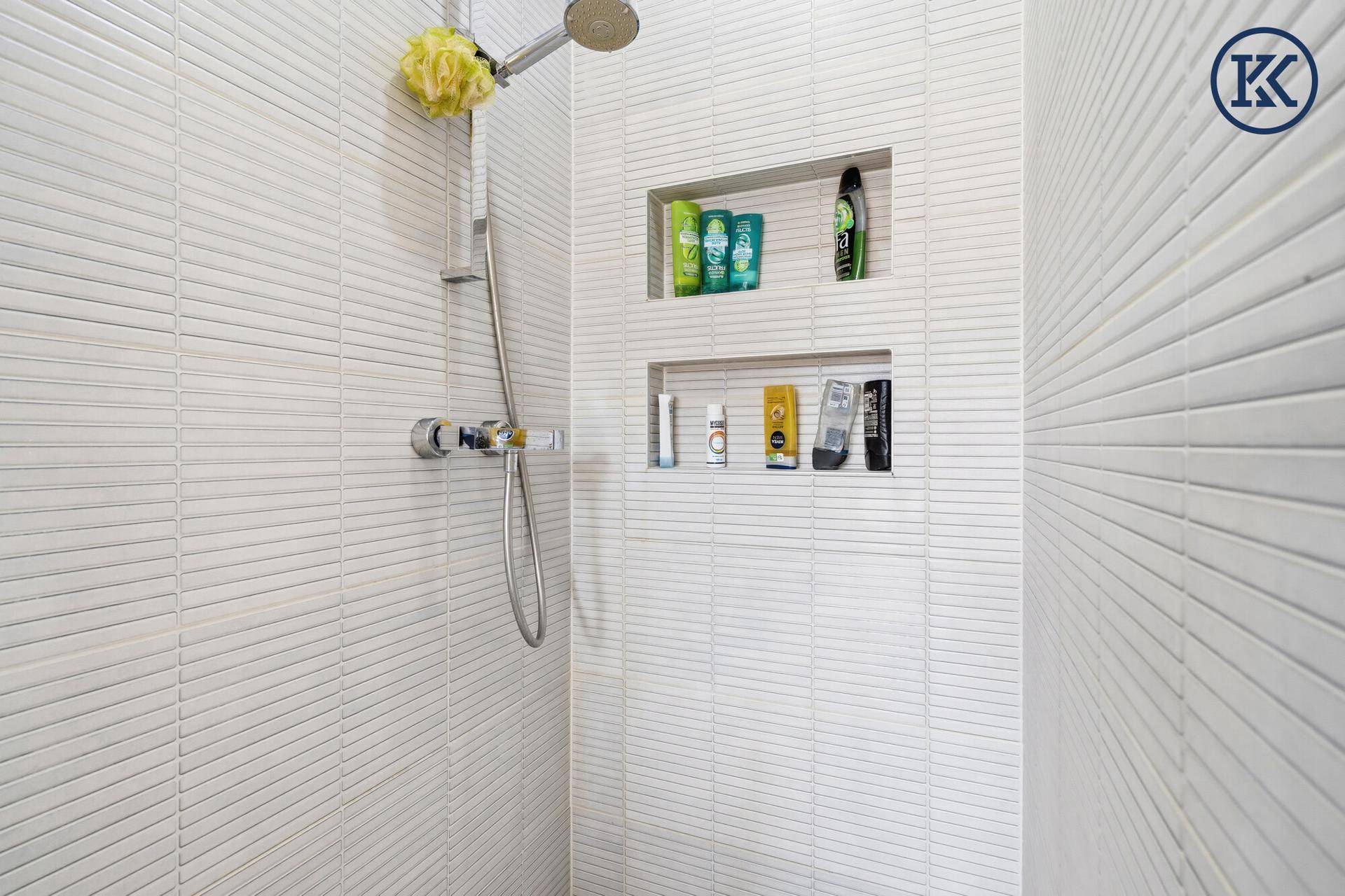 Detaillierte Ansicht der modernen Dusche mit integrierten Ablagen im Badezimmer.